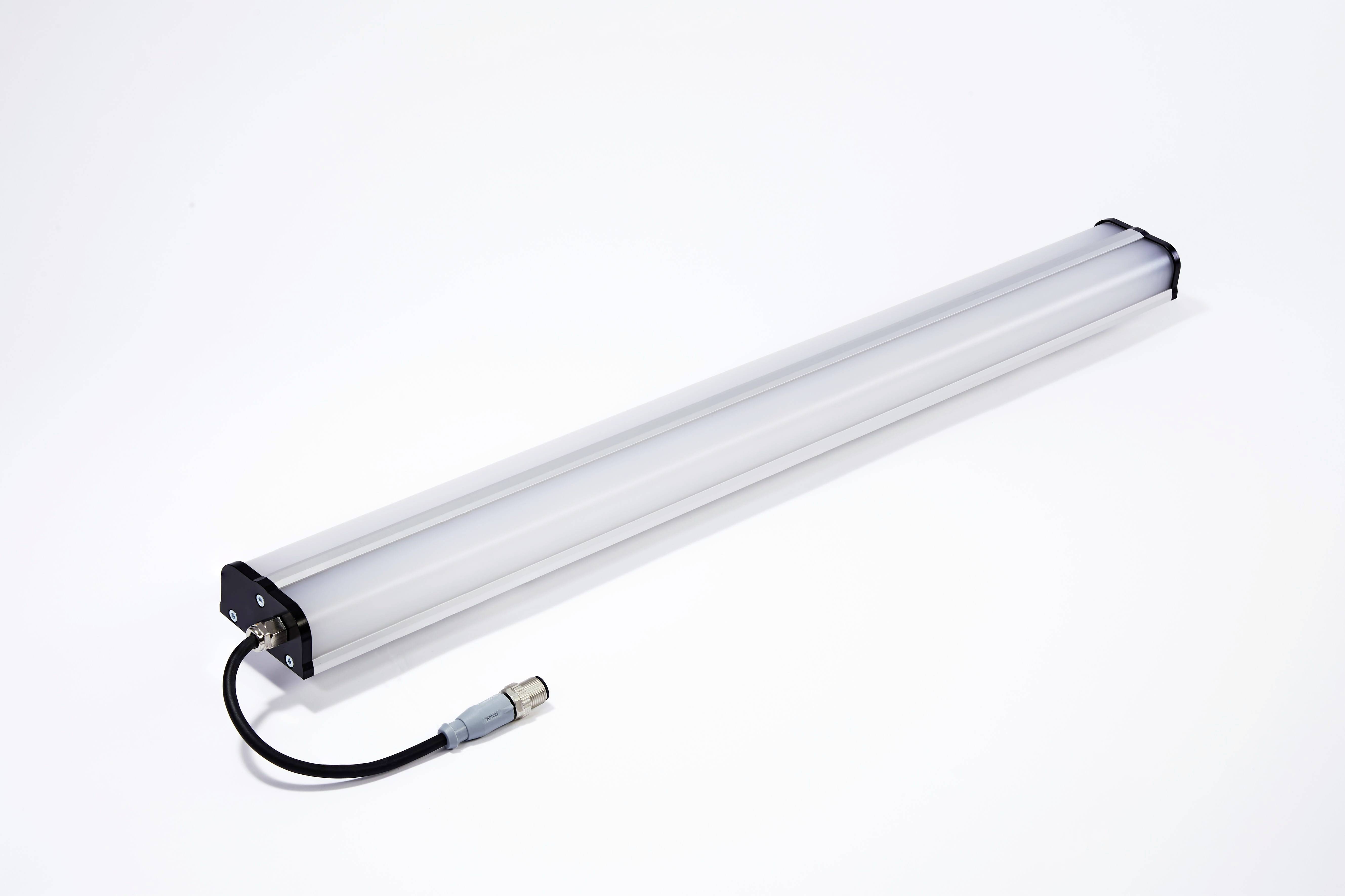 Lange, zylindrische LED-Leuchte mit schwarzem Stecker und Kabel, auf weißem Hintergrund liegend.