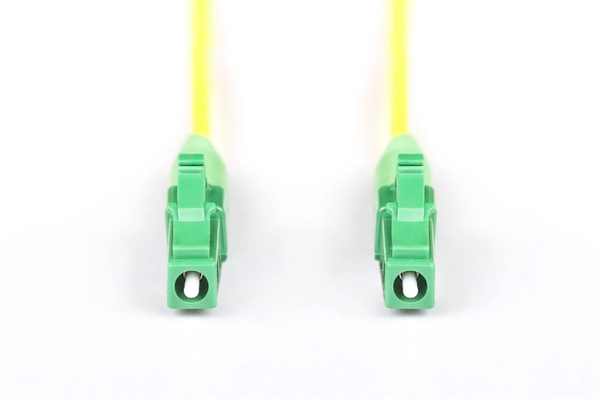 Zwei grüne Glasfaser-Steckverbinder mit gelben Kabeln auf weißem Hintergrund. Sie sind parallel und symmetrisch angeordnet.