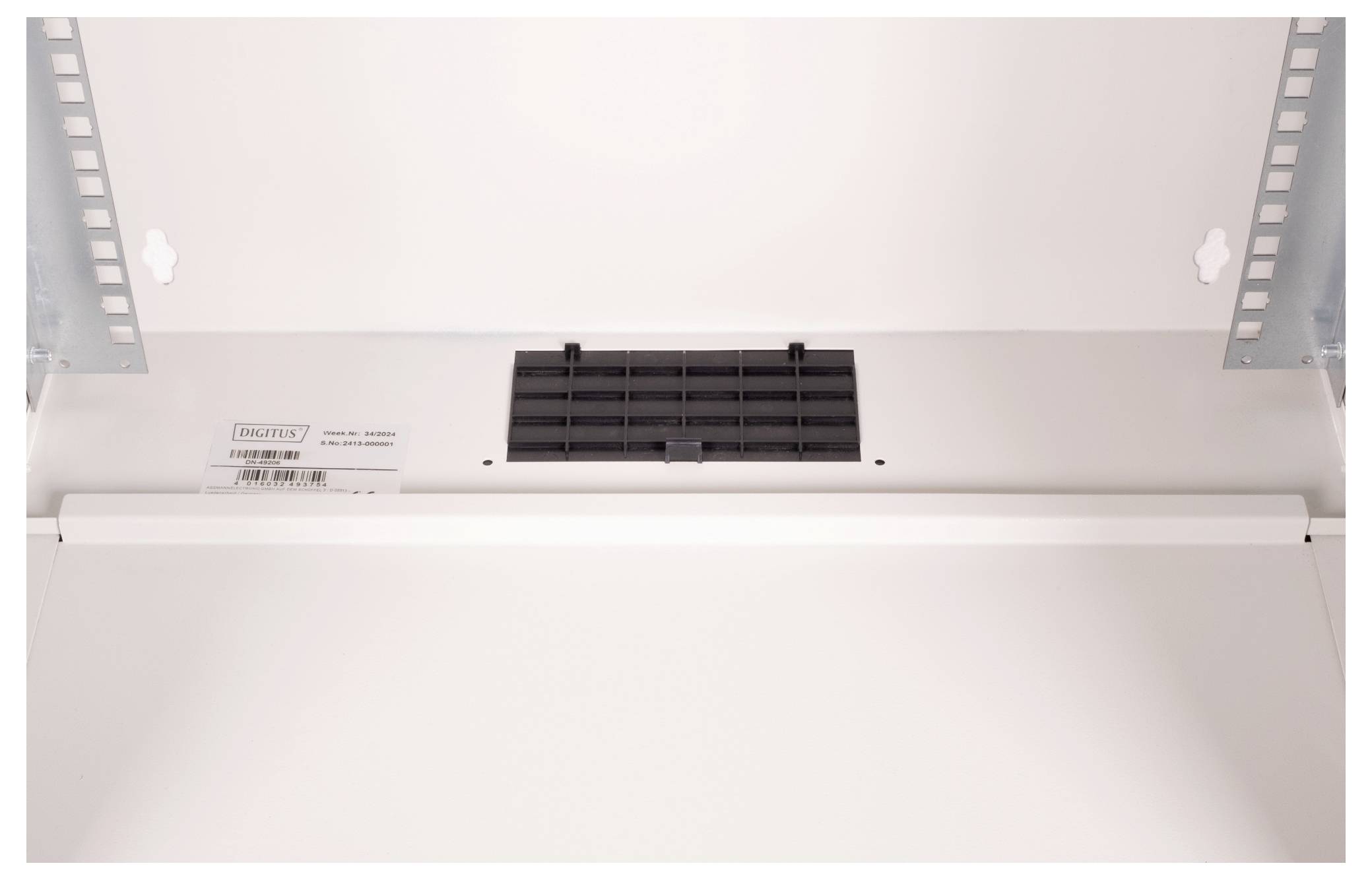 Ein geschlossenes, leeres Elektronikgehäuse mit Lüftungsgitter an der Oberseite.