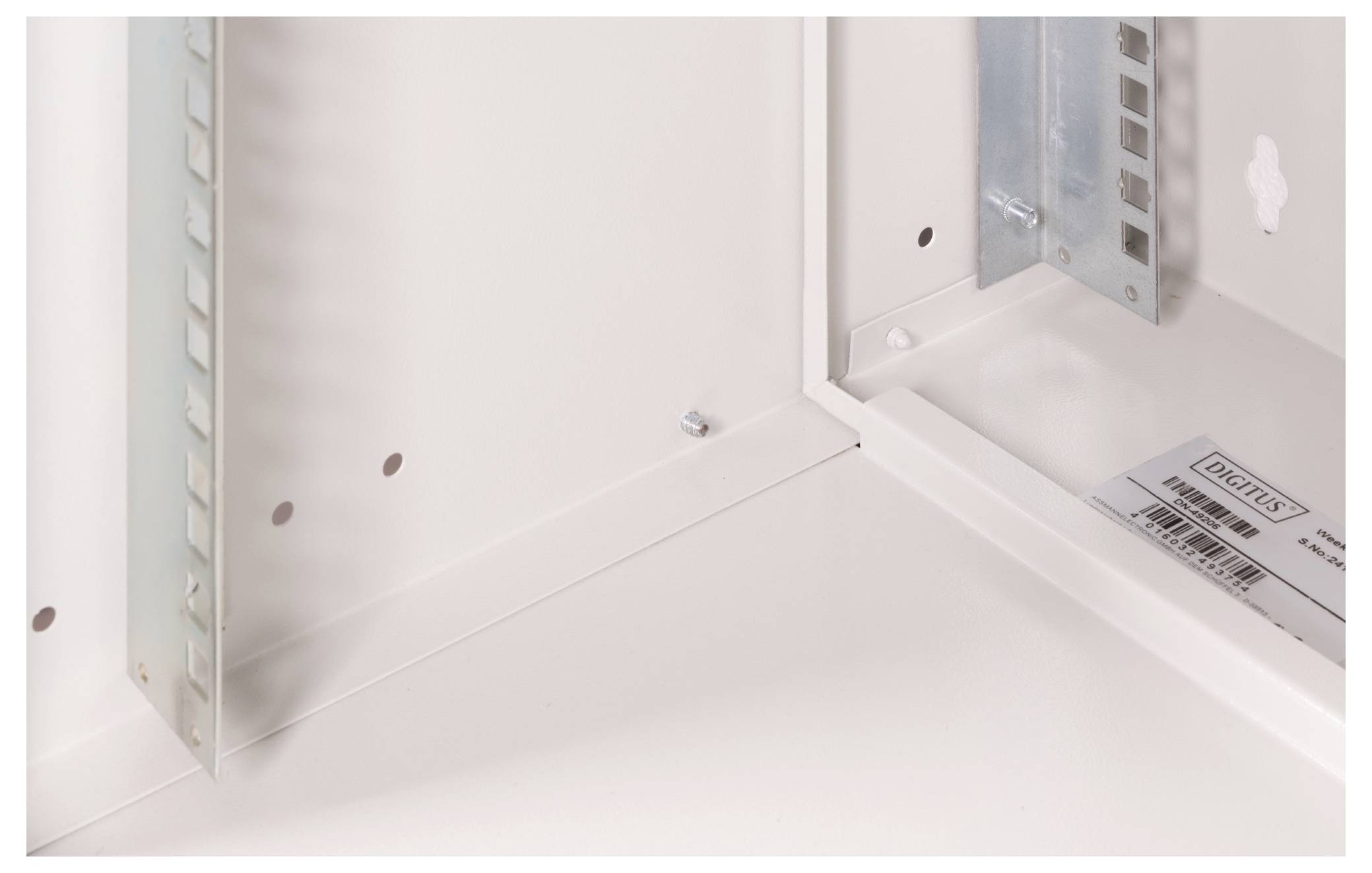 Ein leeres, weißes Metallgehäuse mit sichtbaren Schraubenlöchern und einer dezenten Herstelleretikette rechts unten.