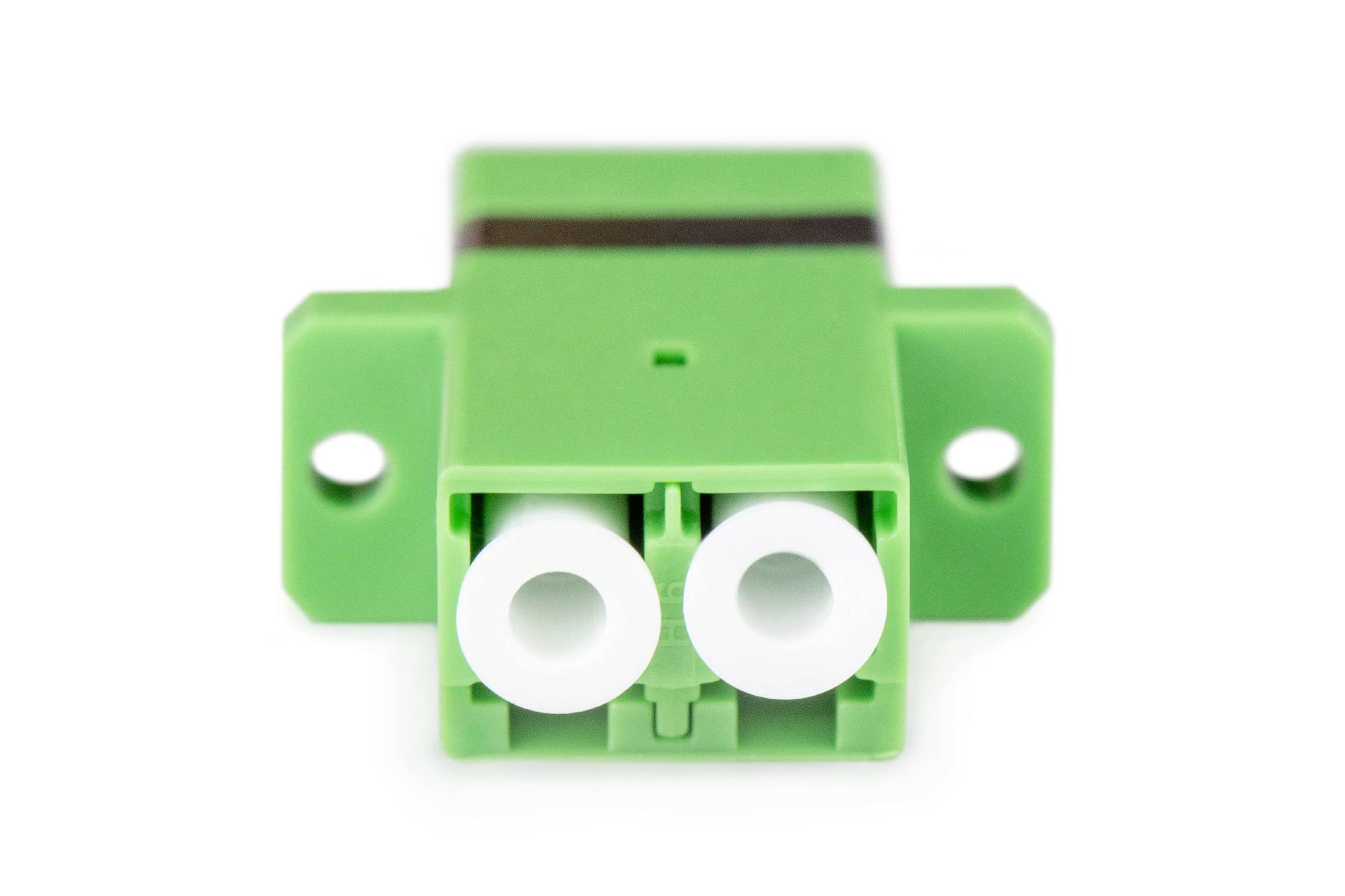 Ein grüner Glasfaseradapter mit zwei Steckplätzen, frontal abgebildet, geeignet für den Anschluss von Glasfaserkabeln.