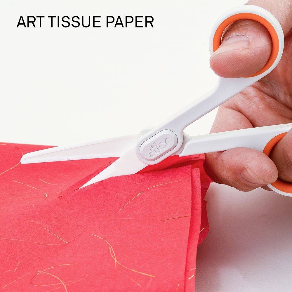 Eine Hand hält eine weiße Schere mit orangefarbenen Griffen und schneidet rotes Seidenpapier. Oben links steht 'ART TISSUE PAPER'.