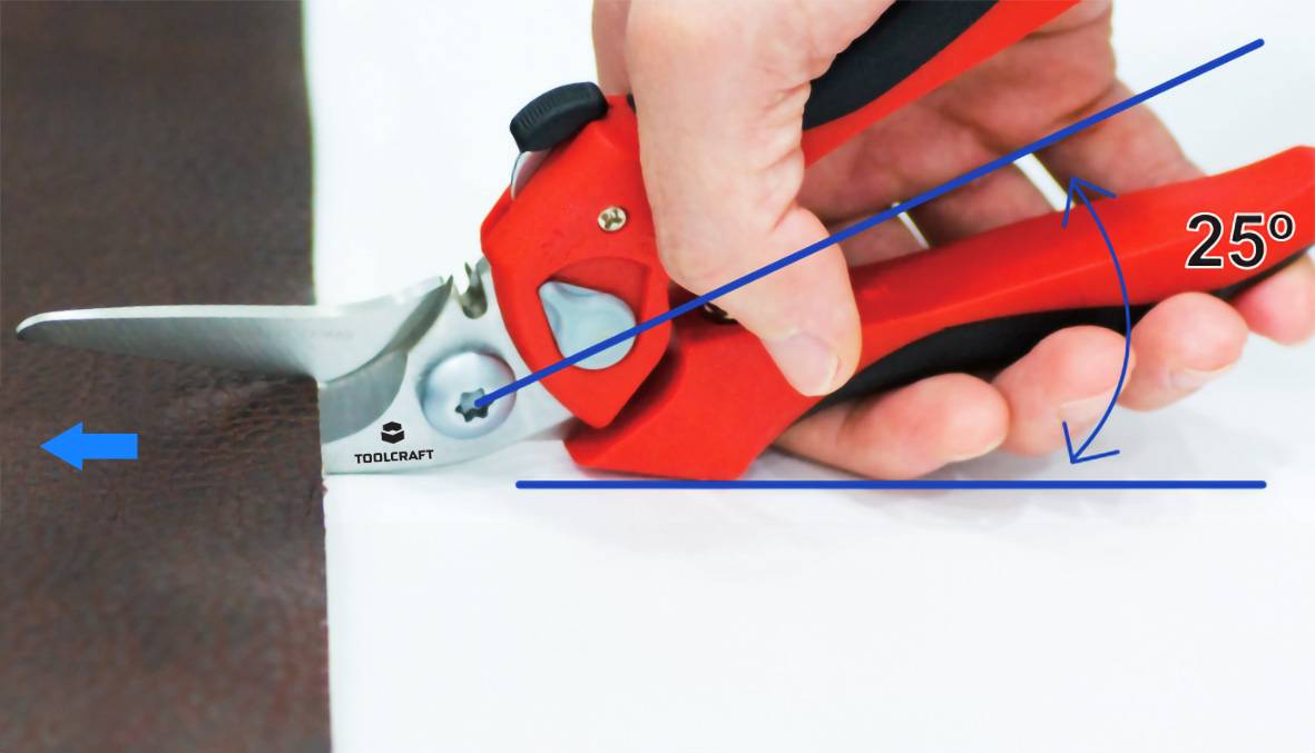 Hand hält eine Schere in einem 25-Grad-Winkel, um präzise zu schneiden. Der Schnitt erfolgt entlang der Kante eines braunen Materials.