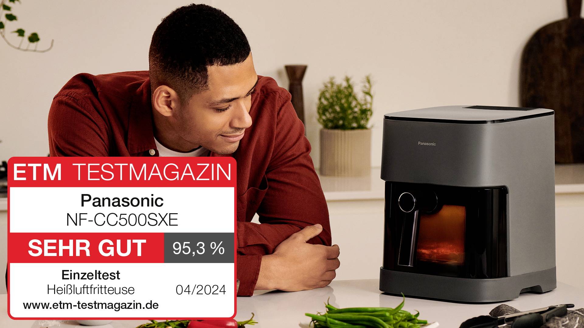 Ein Mann schaut lächelnd auf eine Panasonic-Kaffeemaschine. Ein Testergebnis zeigt 'SEHR GUT' mit 95,3 % Bewertung von ETM Testmagazin.