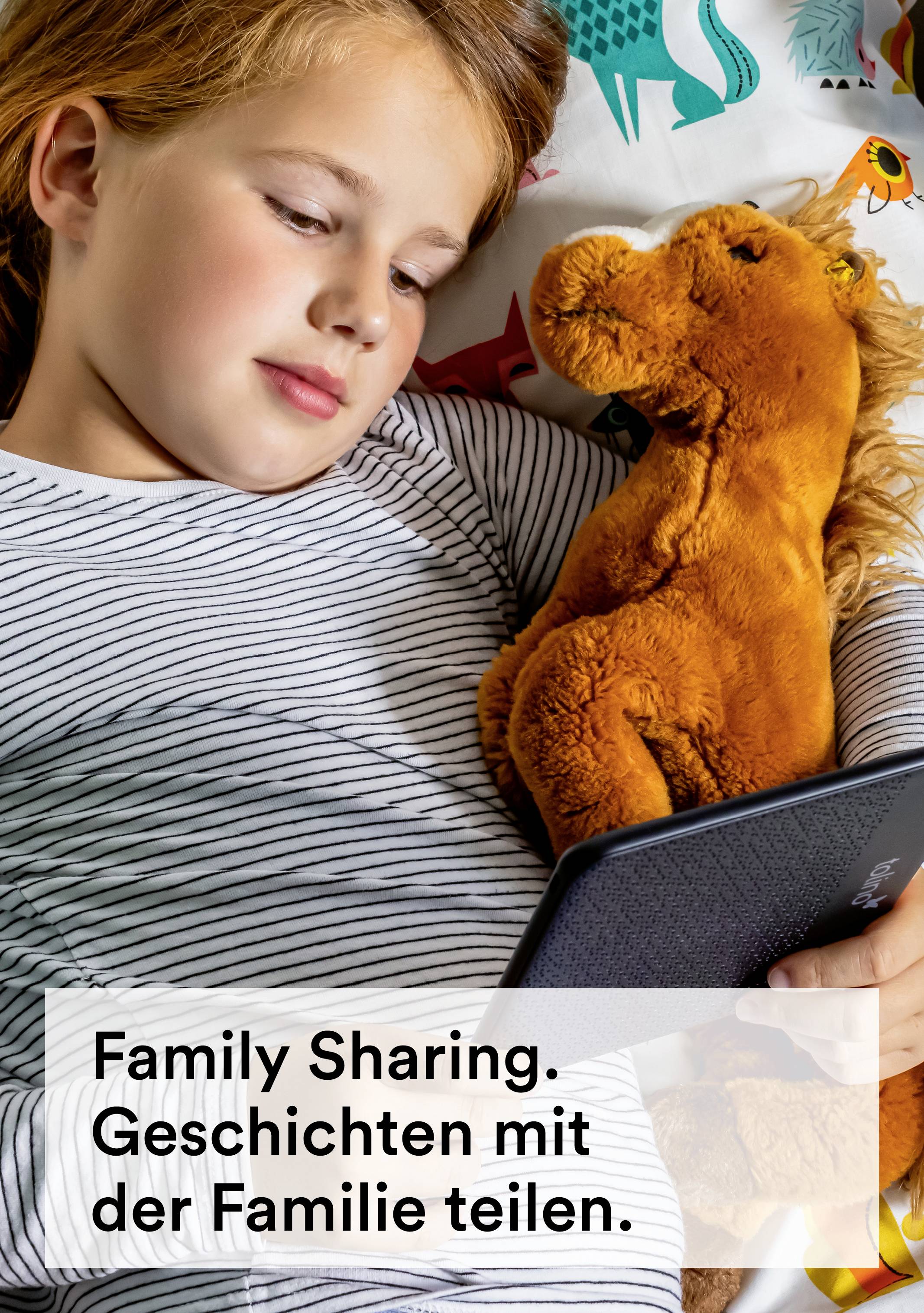 Ein Kind liegt mit einem Kuscheltier im Bett und liest von einem E-Reader. Text auf dem Bild: 'Family Sharing. Geschichten mit der Familie teilen.'