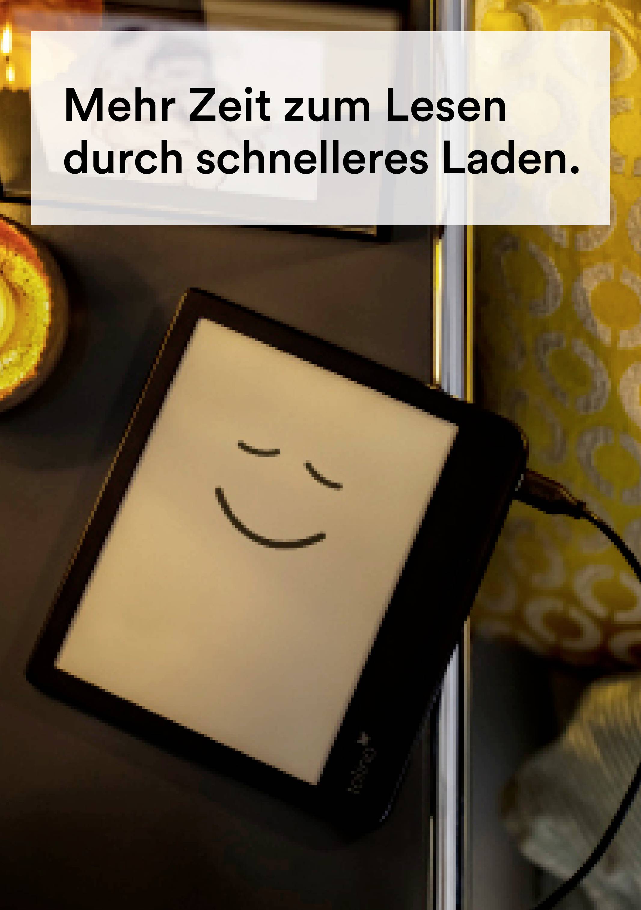 Ein E-Reader liegt auf einem Tisch neben einer Kerze und einem Kissen. Auf dem Bildschirm ist ein lächelndes Gesicht zu sehen. Text: 'Mehr Zeit zum Lesen durch schnelleres Laden.'