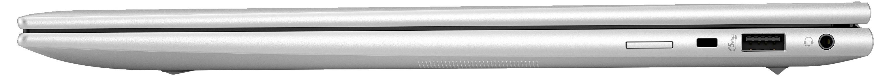 Ein silberner, geschlossener Laptop von der Seite, mit sichtbaren Anschlüssen und Scharnier, auf einer flachen Oberfläche liegend.