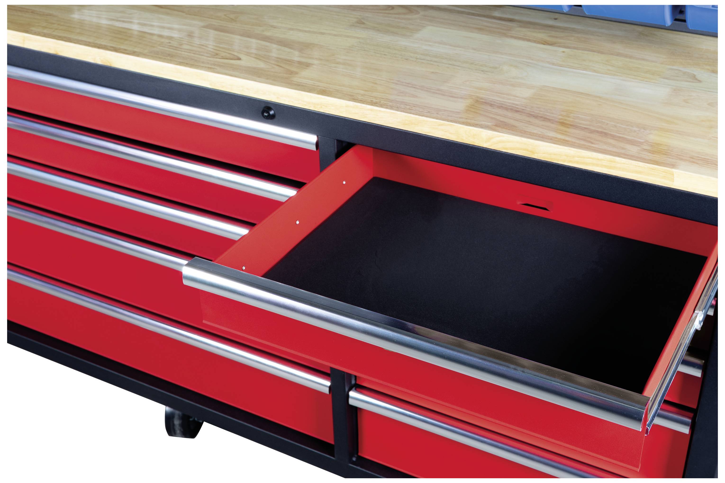 Rote Werkbank mit offenem Schubfach, stabile Holzarbeitsplatte, mehrere geschlossene Schubladen darunter, auf Rädern.