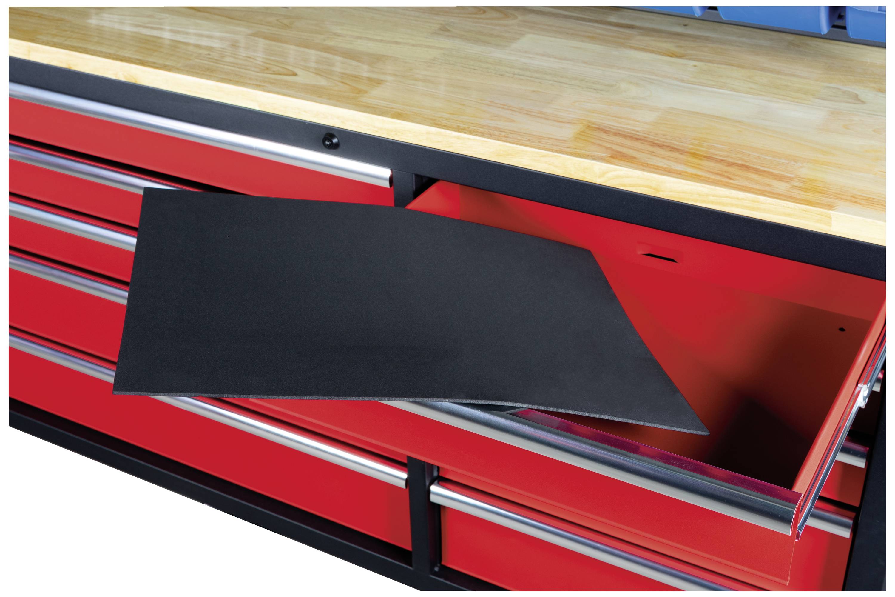 Eine rote Werkbank mit mehreren Schubladen, eine ist offen. Eine schwarze Antirutschmatte ist teilweise aus der offenen Schublade gezogen.