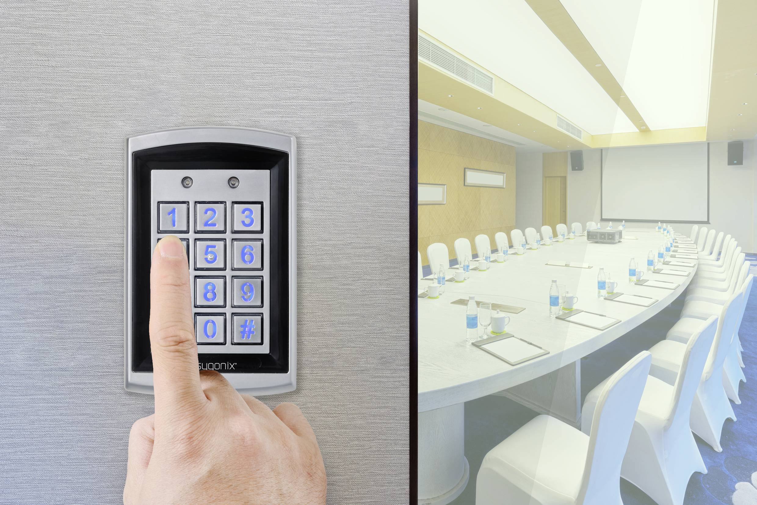 Ein Finger drückt eine Taste auf einem Türschloss mit Nummernfeld. Rechts ein Konferenzraum mit ovalem Tisch und weißen Stühlen.