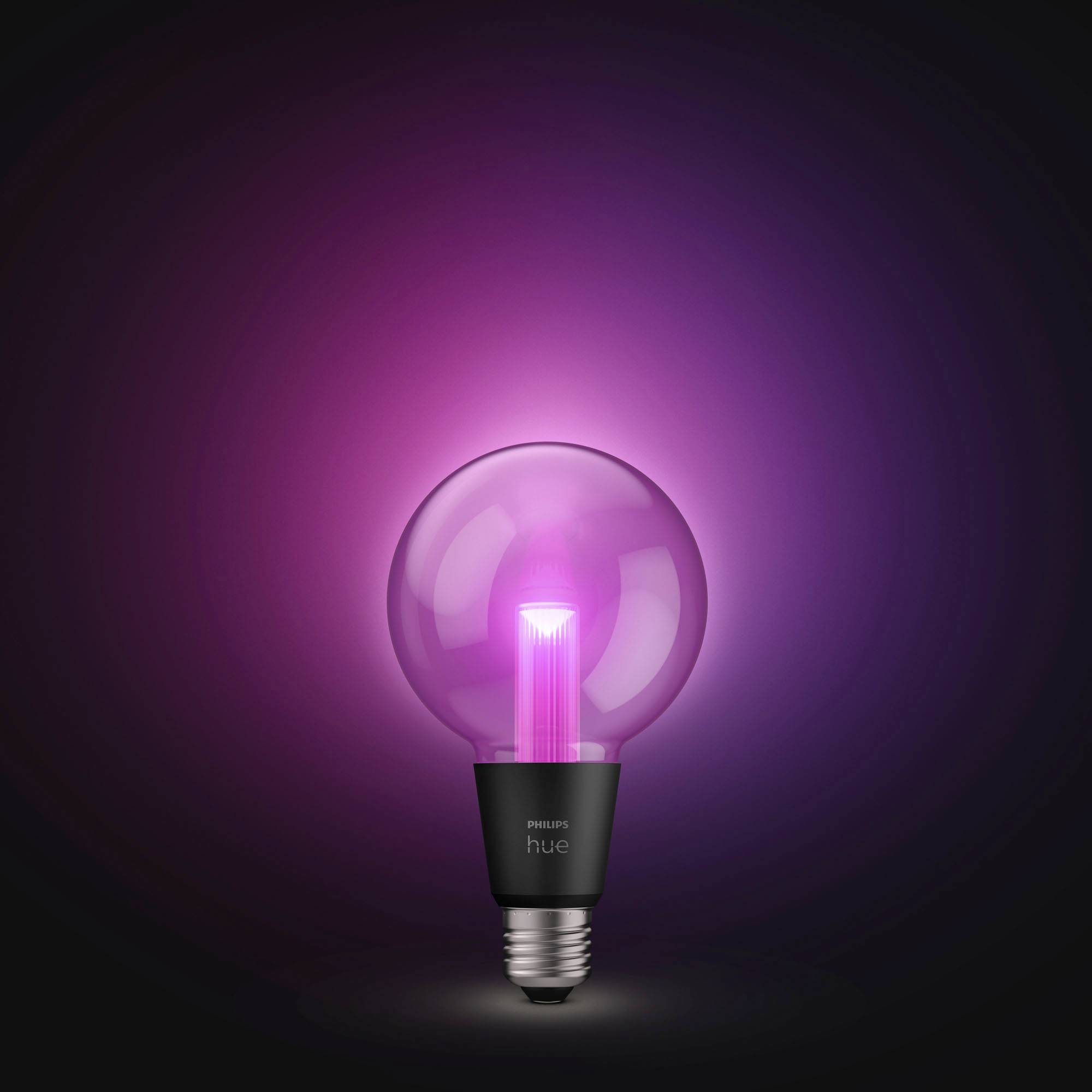 Eine glühende, pinke Glühbirne der Marke Philips Hue vor schwarzem Hintergrund, die modernes und stimmungsvolles Licht ausstrahlt.