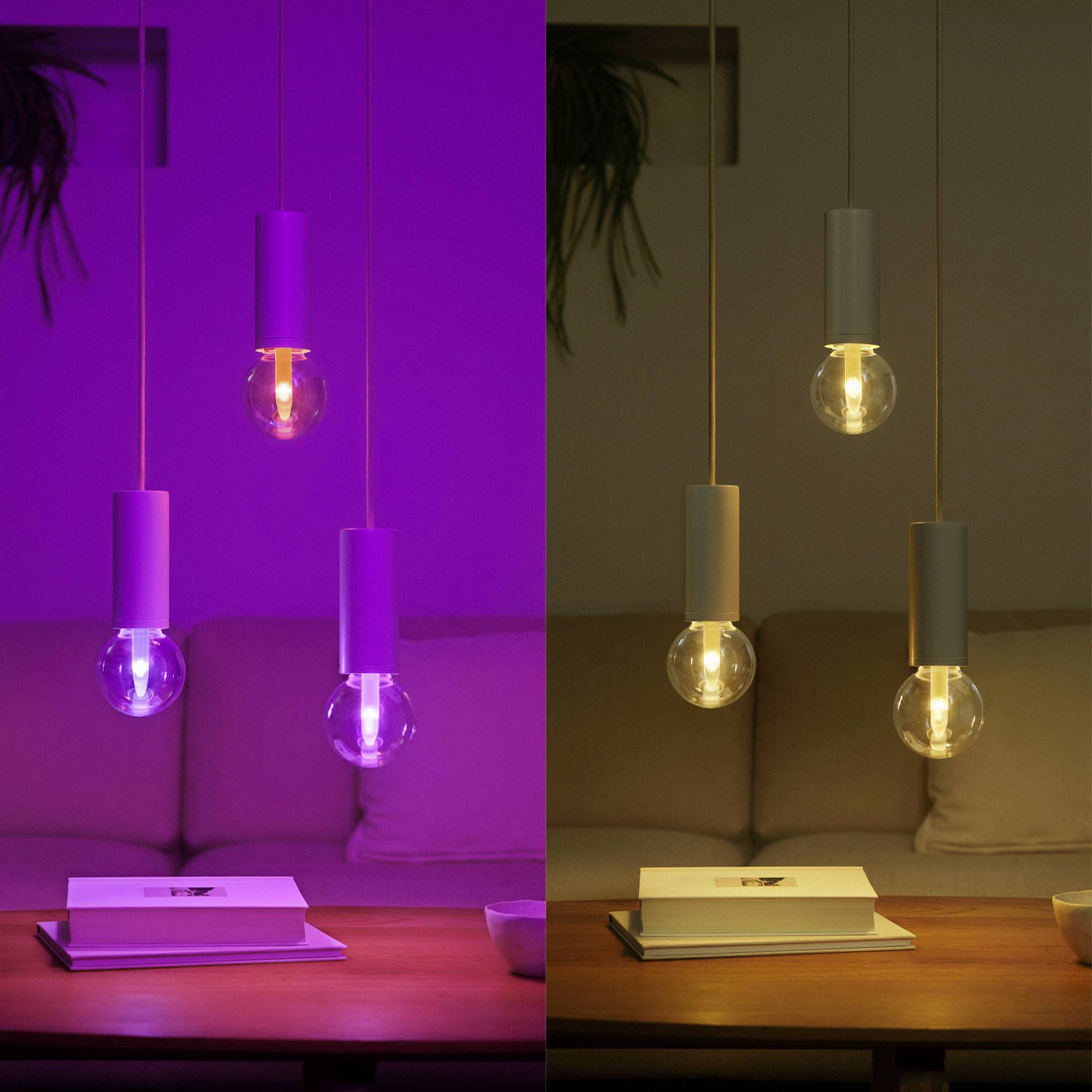 Zwei Fotos nebeneinander zeigen zwei Glühbirnen, eine in violettem Licht und eine im warmen Weiß, über einem Tisch mit Buch und Sofa.