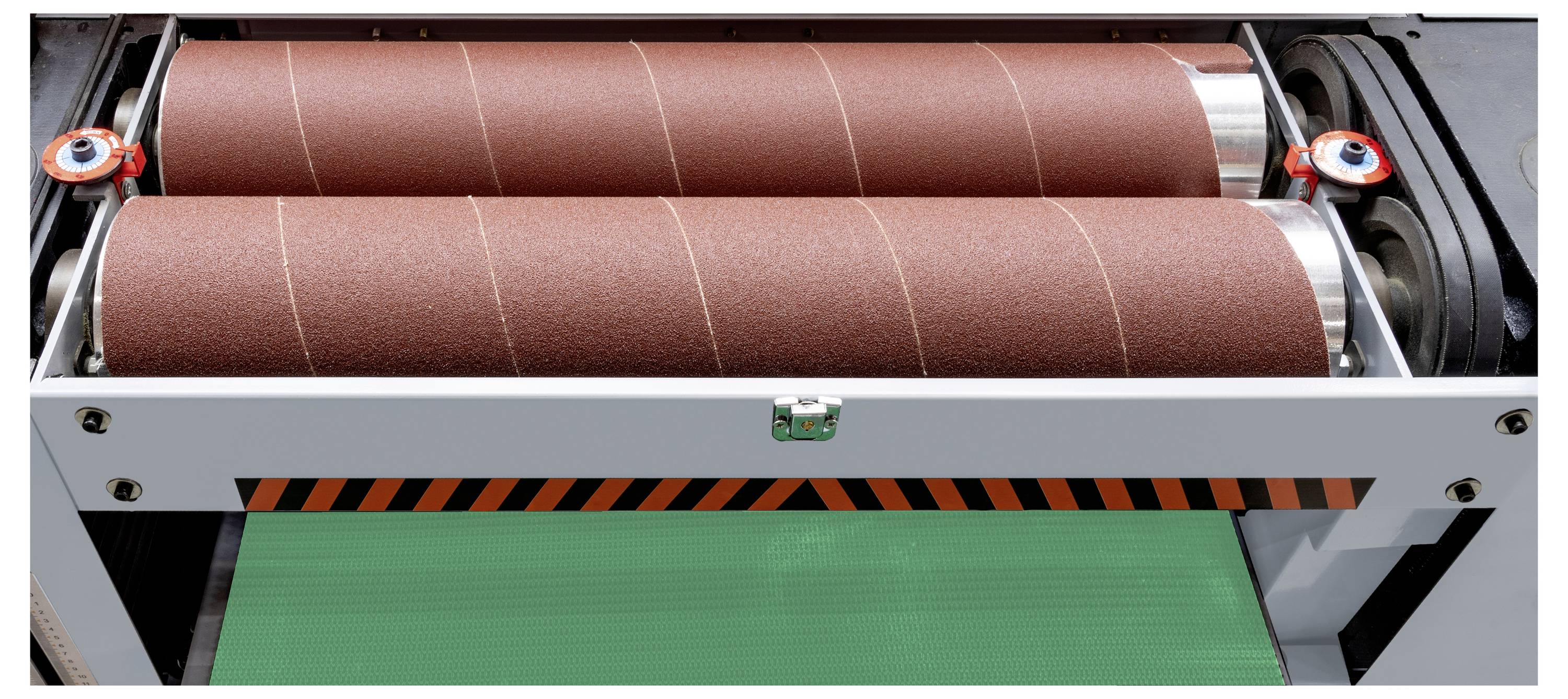 Eine Holzbearbeitungsmaschine mit zwei großen Schleifwalzen, die parallel zueinander angeordnet sind, über einem grünen Förderband.