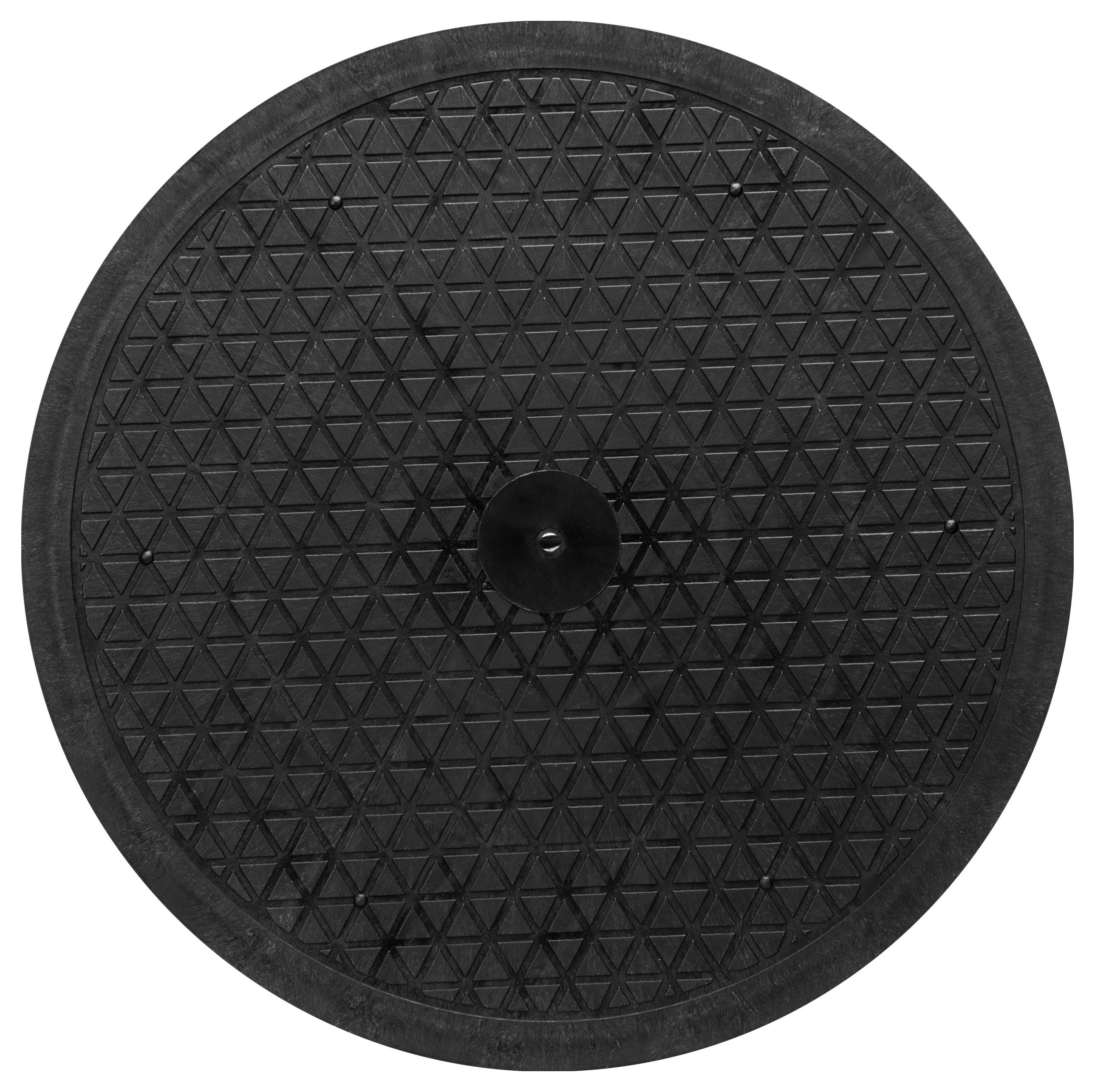 Rundes, schwarzes Kunststoffobjekt mit dreieckigem Muster, von oben gesehen.