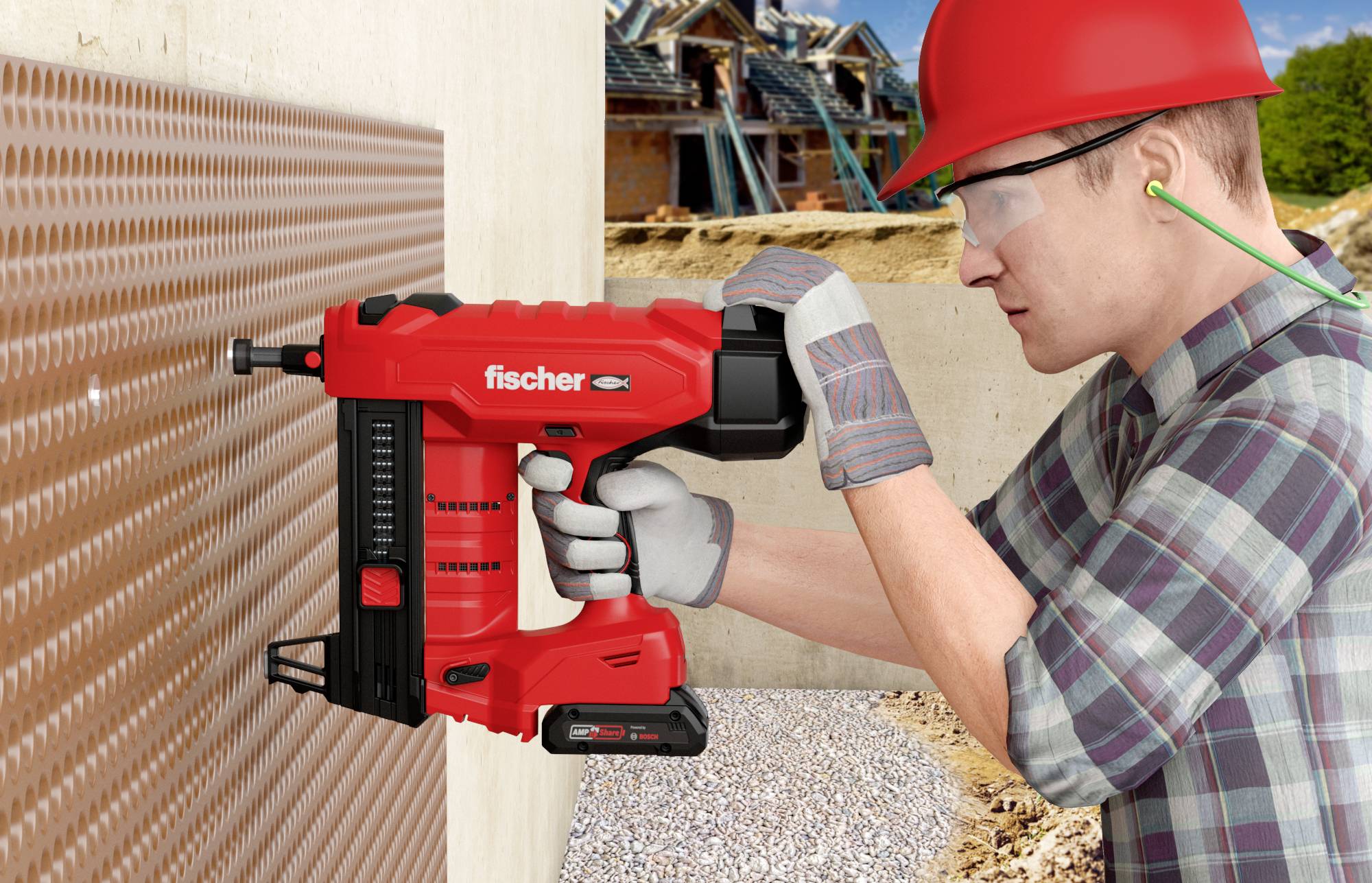 Mann mit Schutzhelm und Gehörschutz benutzt eine rote Nagelpistole, um ein Noppenprofil an einer Betonwand zu befestigen. Hintergrund zeigt Baustelle.