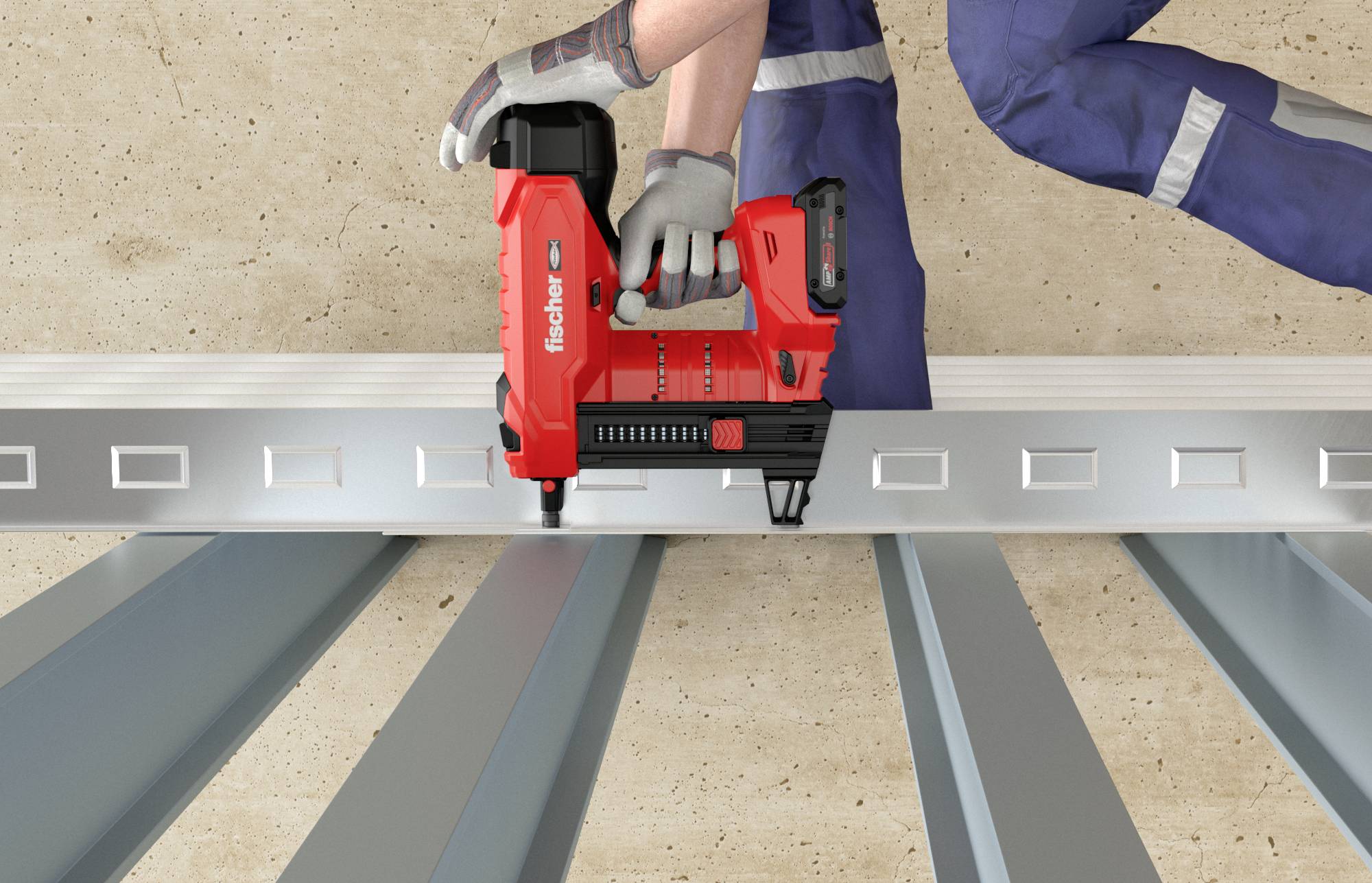 Ein Arbeiter befestigt mit einem roten Nagelgerät Metallprofile auf einem Betonboden.