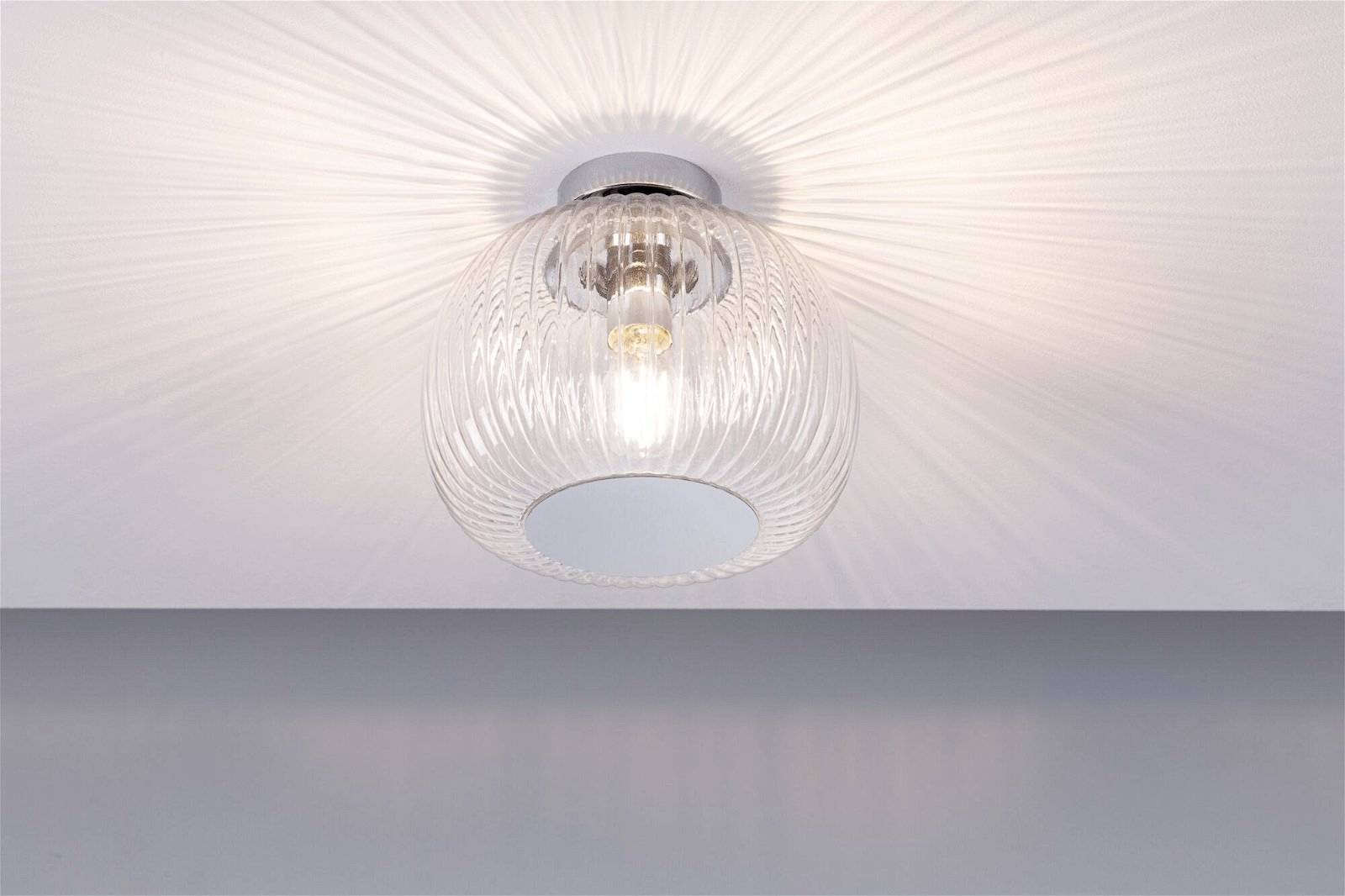 Deckenleuchte mit transparentem, geriffeltem Glas, das ein schönes Lichtmuster an die Decke projiziert.