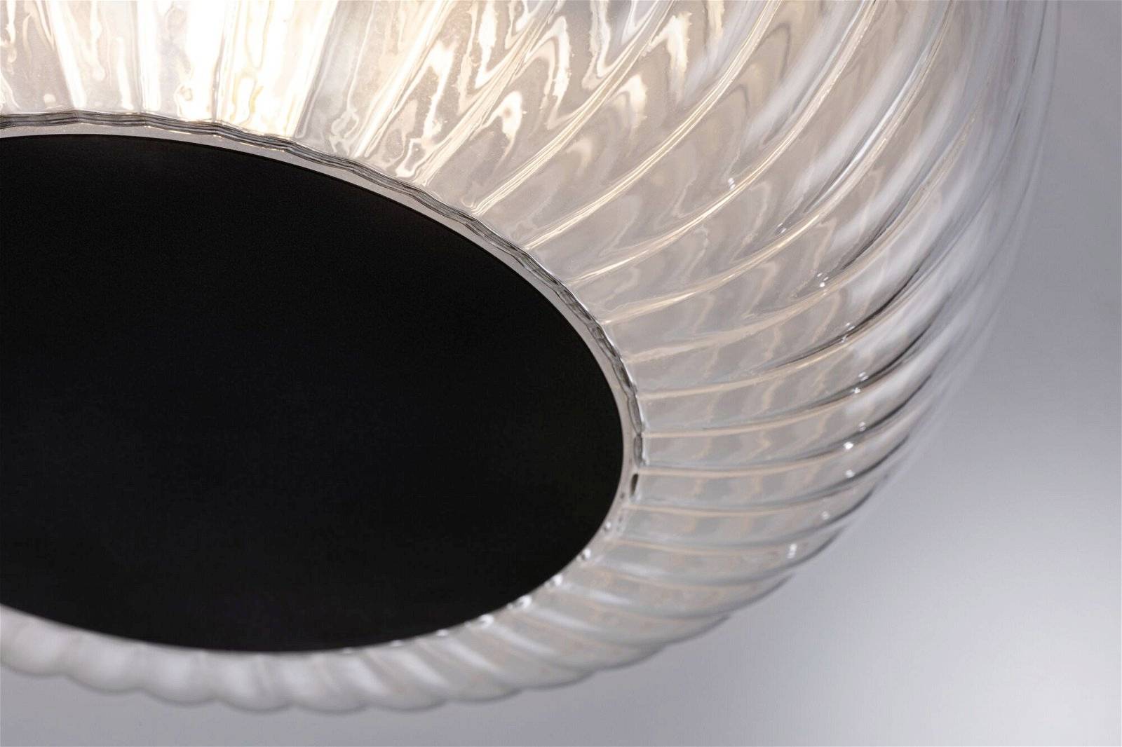 Nahaufnahme einer modernen, transparenten Deckenleuchte mit spiralförmigem Muster und schwarzem Inneren, die diffuses Licht abstrahlt.