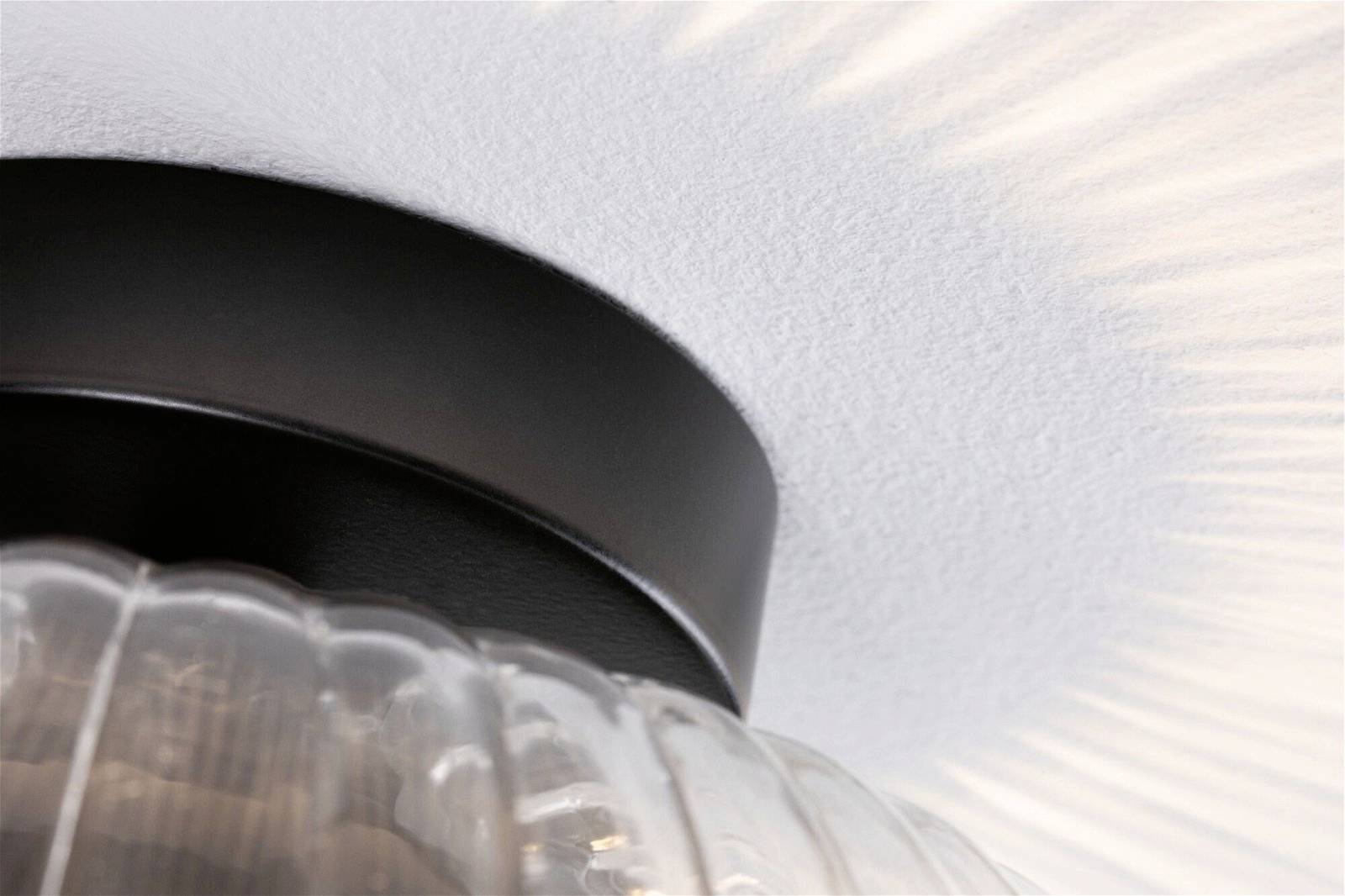 Deckenlampe mit kreisförmigem Lichteffekt auf weißer Oberfläche.