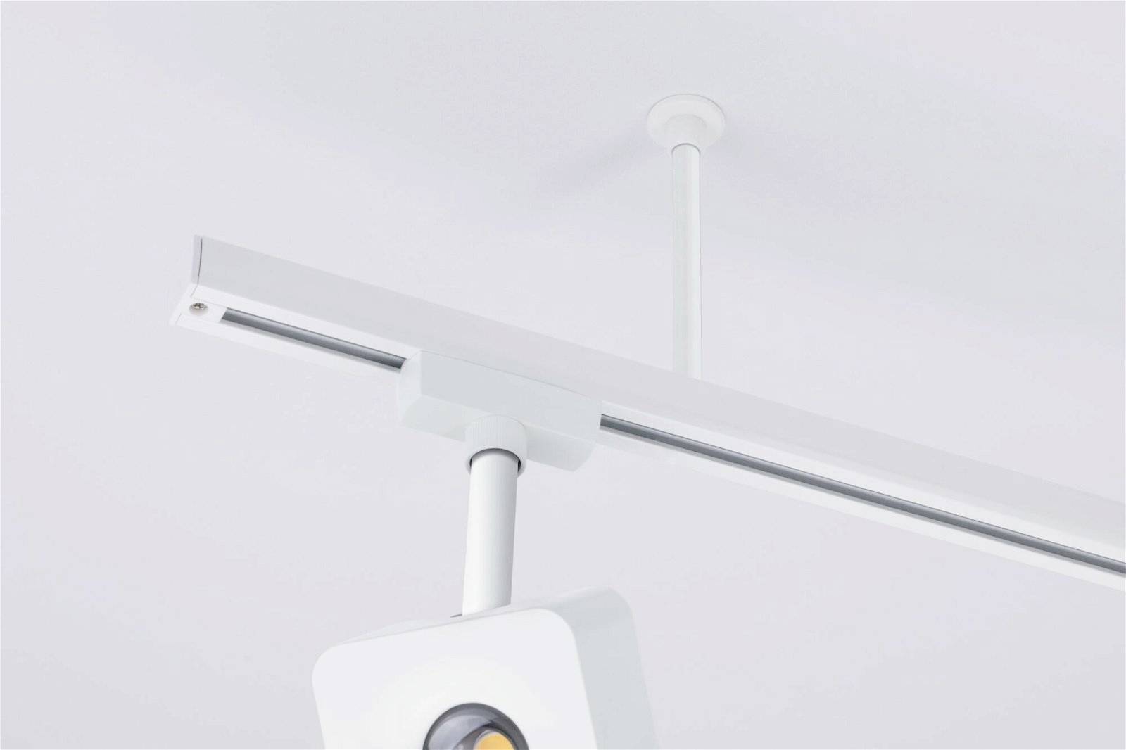 Schienensystemleuchte an weißer Decke montiert, modernes Design, für gerichtete Beleuchtung in Innenräumen geeignet.
