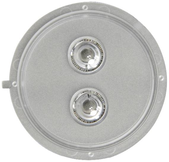 Ein silbernes rundes Objekt mit zwei kleinen, gläsernen Linsen oder Knöpfen in der Mitte, vor neutralem Hintergrund.