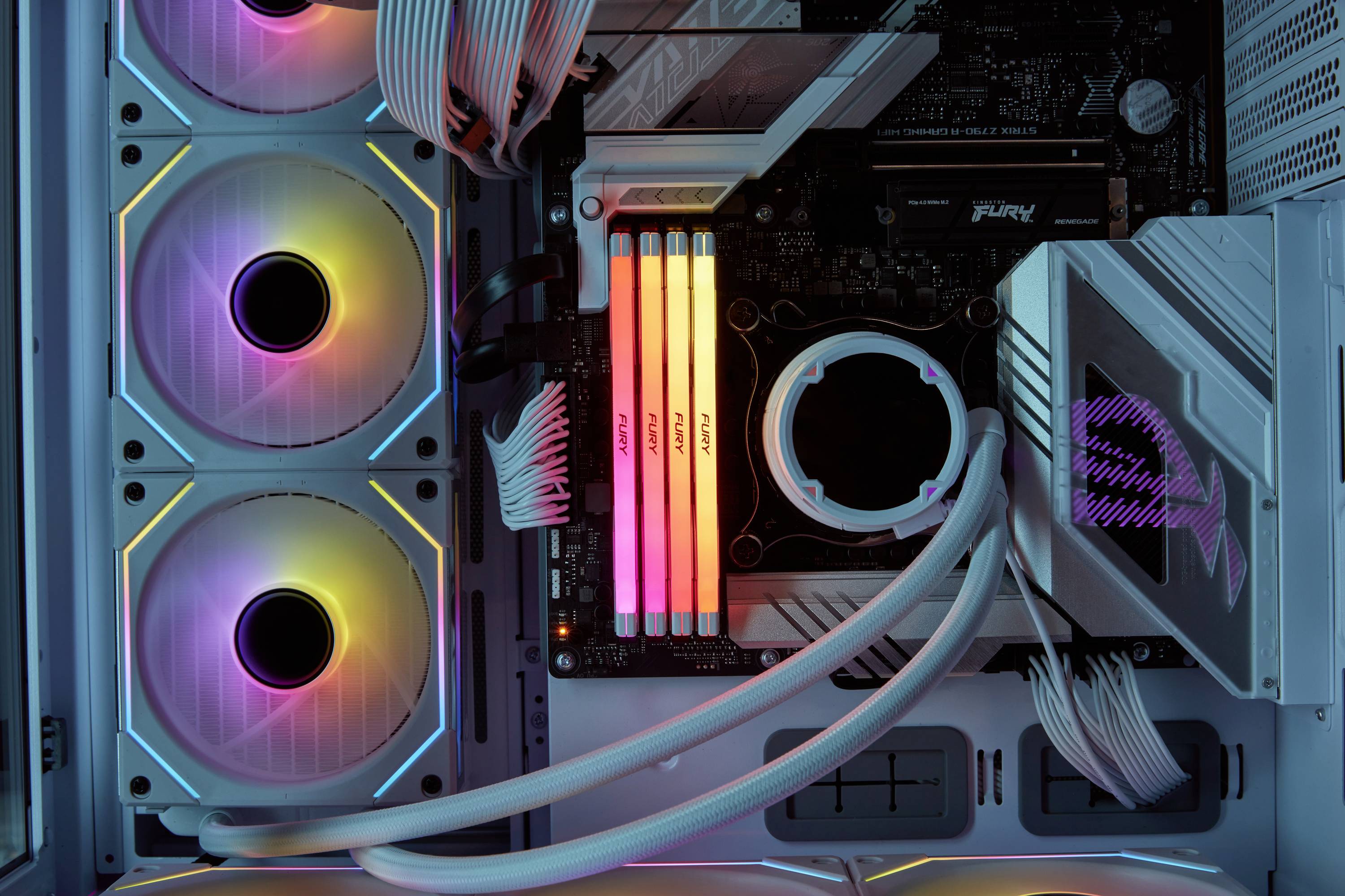 Blick ins Innere eines Computergehäuses mit RGB-beleuchteten Lüftern und RAM-Sticks, die in verschiedenen Farben leuchten.