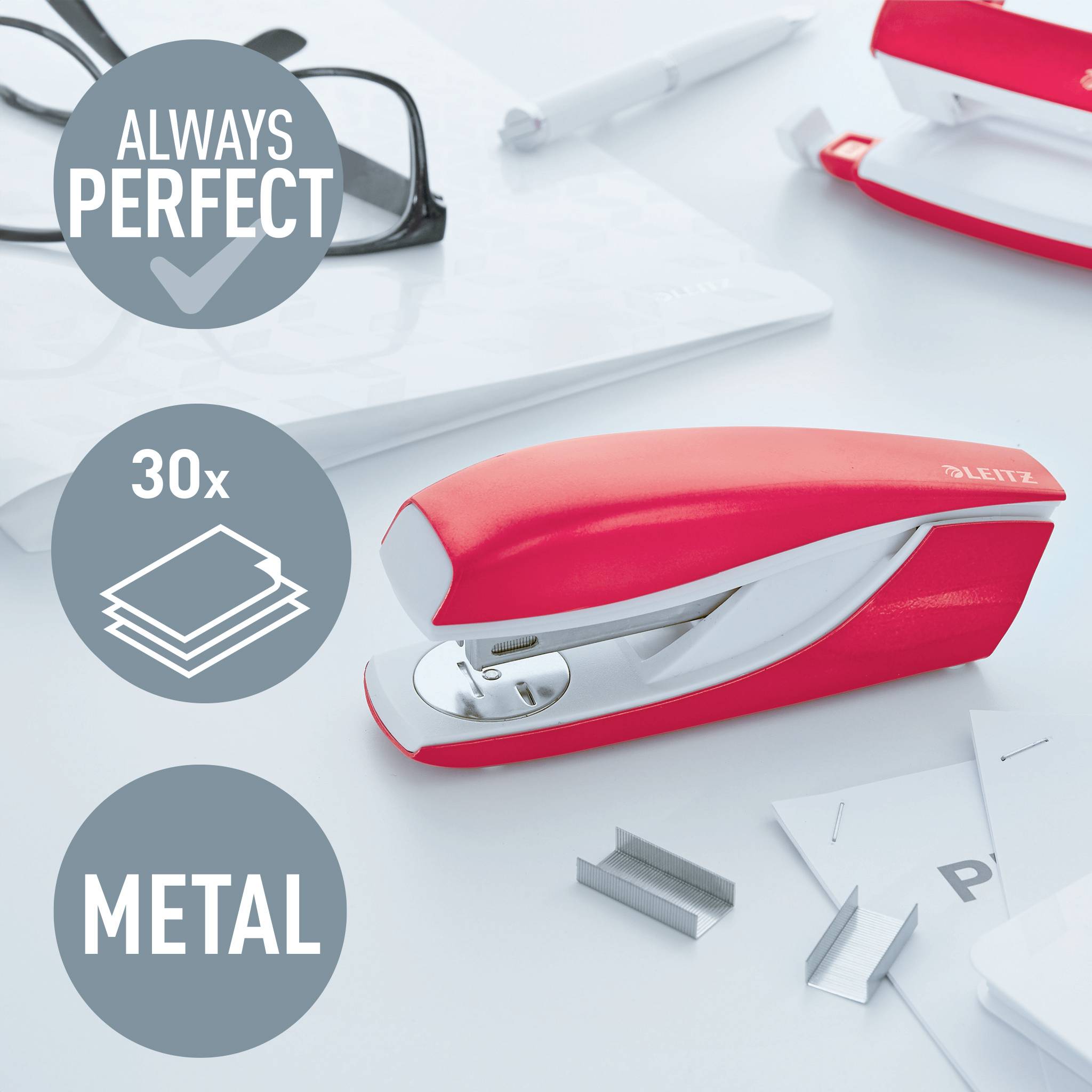Roter, metallischer Hefter auf einem Schreibtisch neben Papier und Büroklammern. Text: 'ALWAYS PERFECT', '30x', 'METAL'.