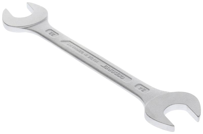 Ein silberner Doppelmaulschlüssel, eine Seite 22 mm, die andere 24 mm, liegt auf einer weißen Oberfläche.