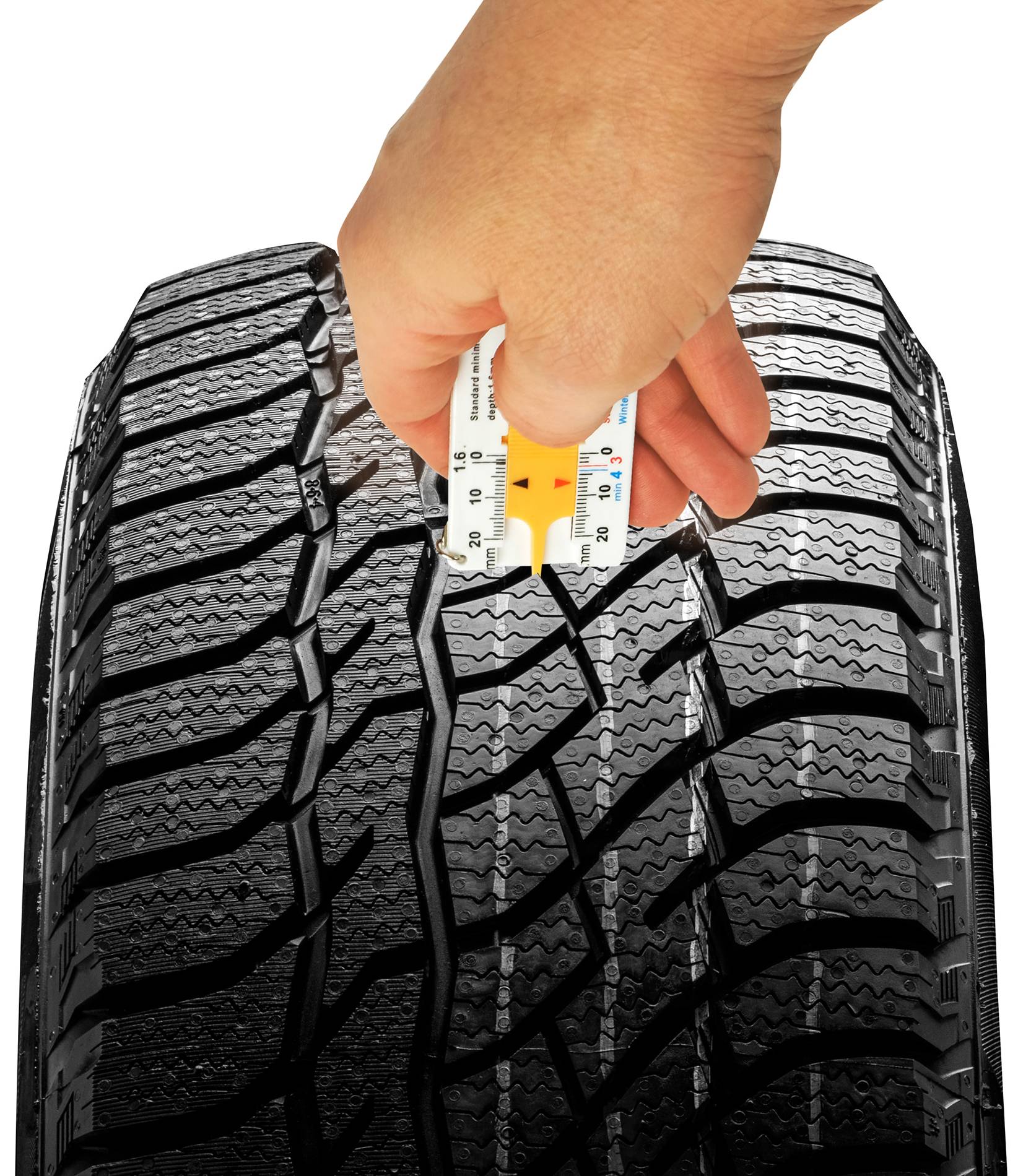 Eine Hand misst die Profiltiefe eines Autoreifens mit einem speziellen Werkzeug, um die Verkehrstauglichkeit zu überprüfen.