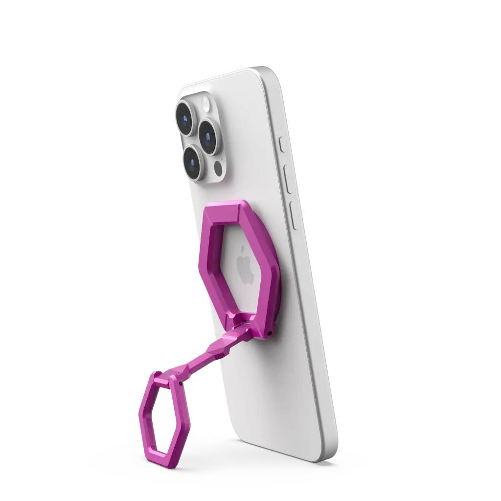 Rosa, faltbarer Handyhalter stützt ein Smartphone aufrecht. Der Halter hat eine Wabenstruktur und ist an das Gerät angesteckt.