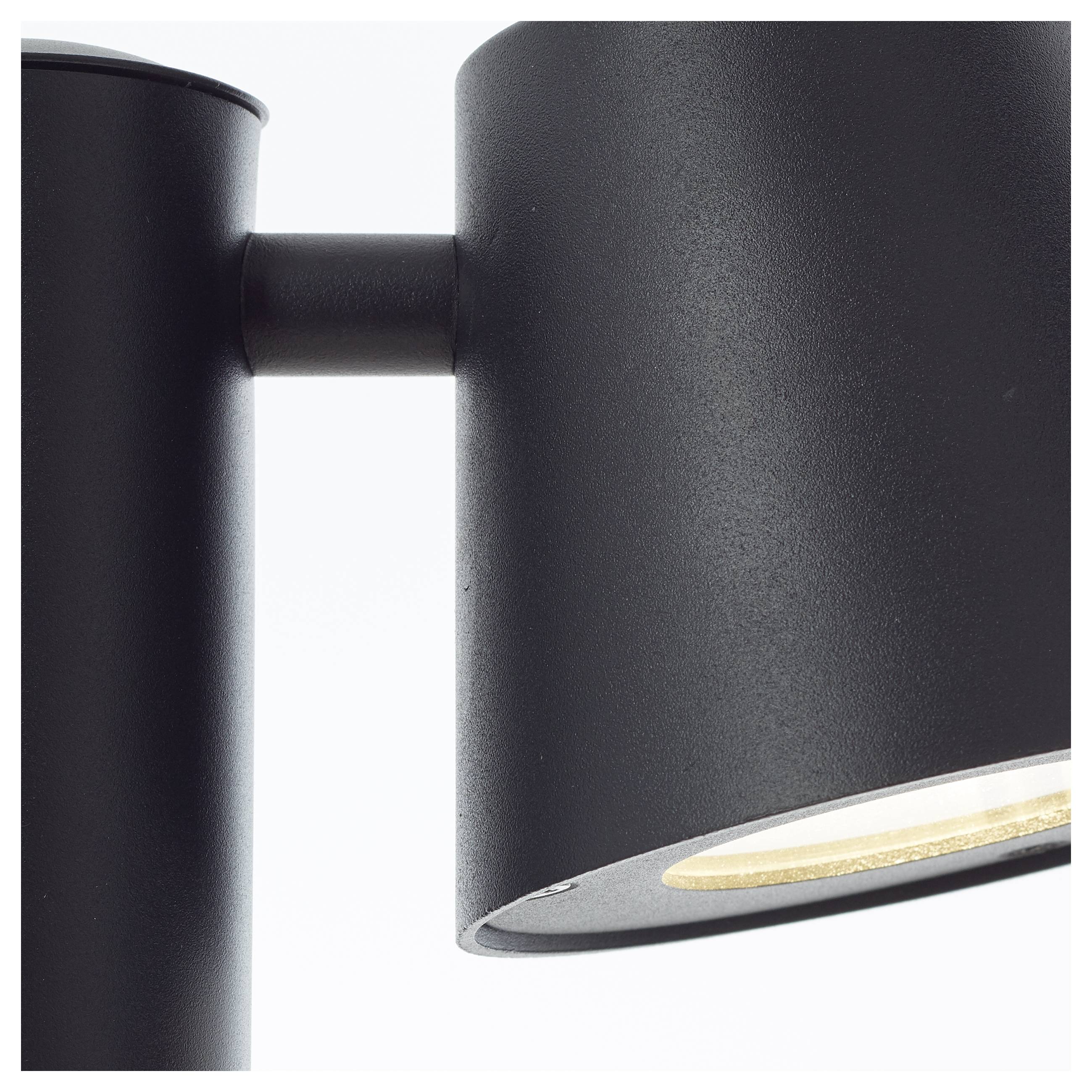 Eine schwarze Wandleuchte mit zylindrischem Lampenschirm, die nach rechts gerichtet ist, vor einem weißen Hintergrund.