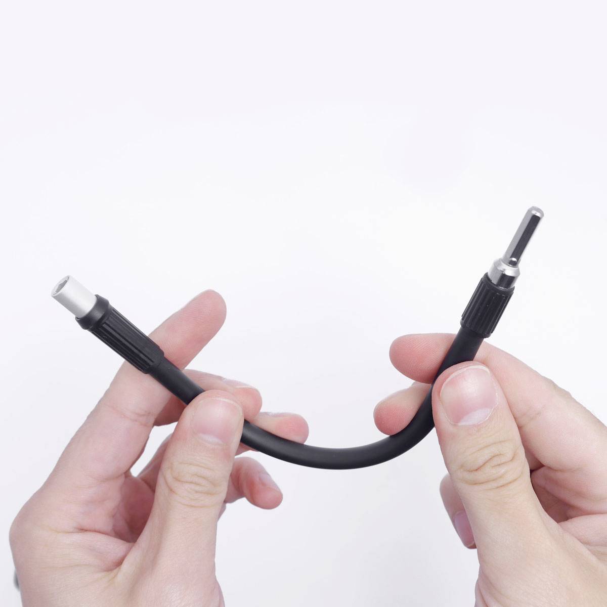 Hände halten ein schwarzes Audiokabel mit zwei Metallsteckern.