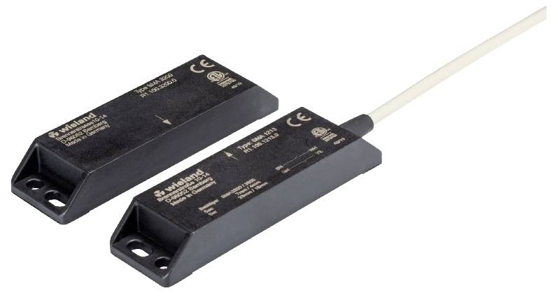 Zwei schwarze elektronische Geräte mit CE-Kennzeichnung und Kabelanschluss, möglicherweise Sensoren.