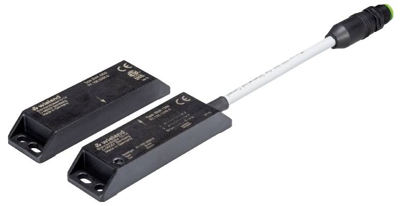 Zwei schwarze Magnetsensoren mit einem Kabelanschluss, gekennzeichnet mit Herstellerinformationen. Sie sind für industrielle Sicherheitsanwendungen konzipiert.