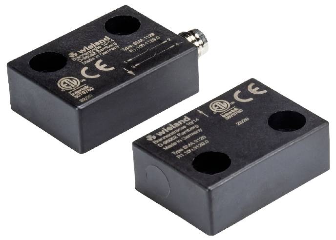 Zwei rechteckige schwarze elektrische Komponenten mit CE-Kennzeichnung und Anschlussstecker, beschriftet mit technischer Information.