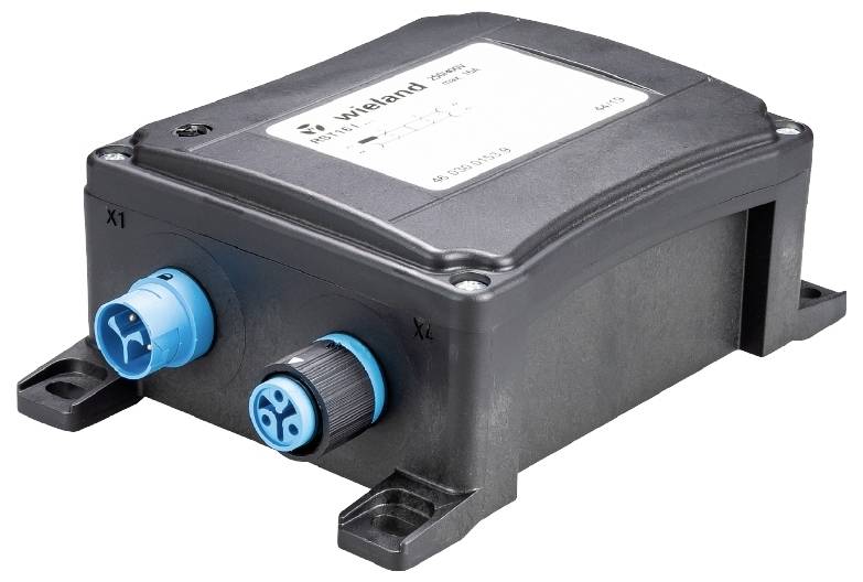 Schwarzes elektrisches Gehäuse mit zwei blauen Anschlüssen, beschriftet als 'wieland pesnel', zur Verbindung von Kabeln, auf einer weißen Oberfläche.