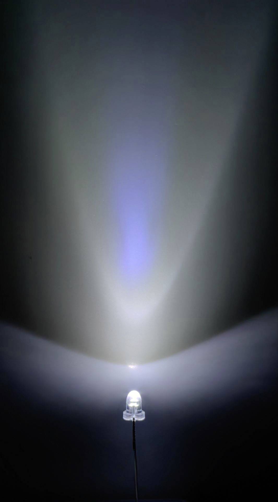 Eine LED-Lampe strahlt Licht in verschiedenen Blau- und Weiß-Tönen aus, projiziert auf eine Wand.