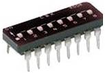 Eine rechteckige elektronische Komponente mit mehreren Anschlüssen, wahrscheinlich ein integrierter Schaltkreis-Chip, auf weißem Hintergrund.