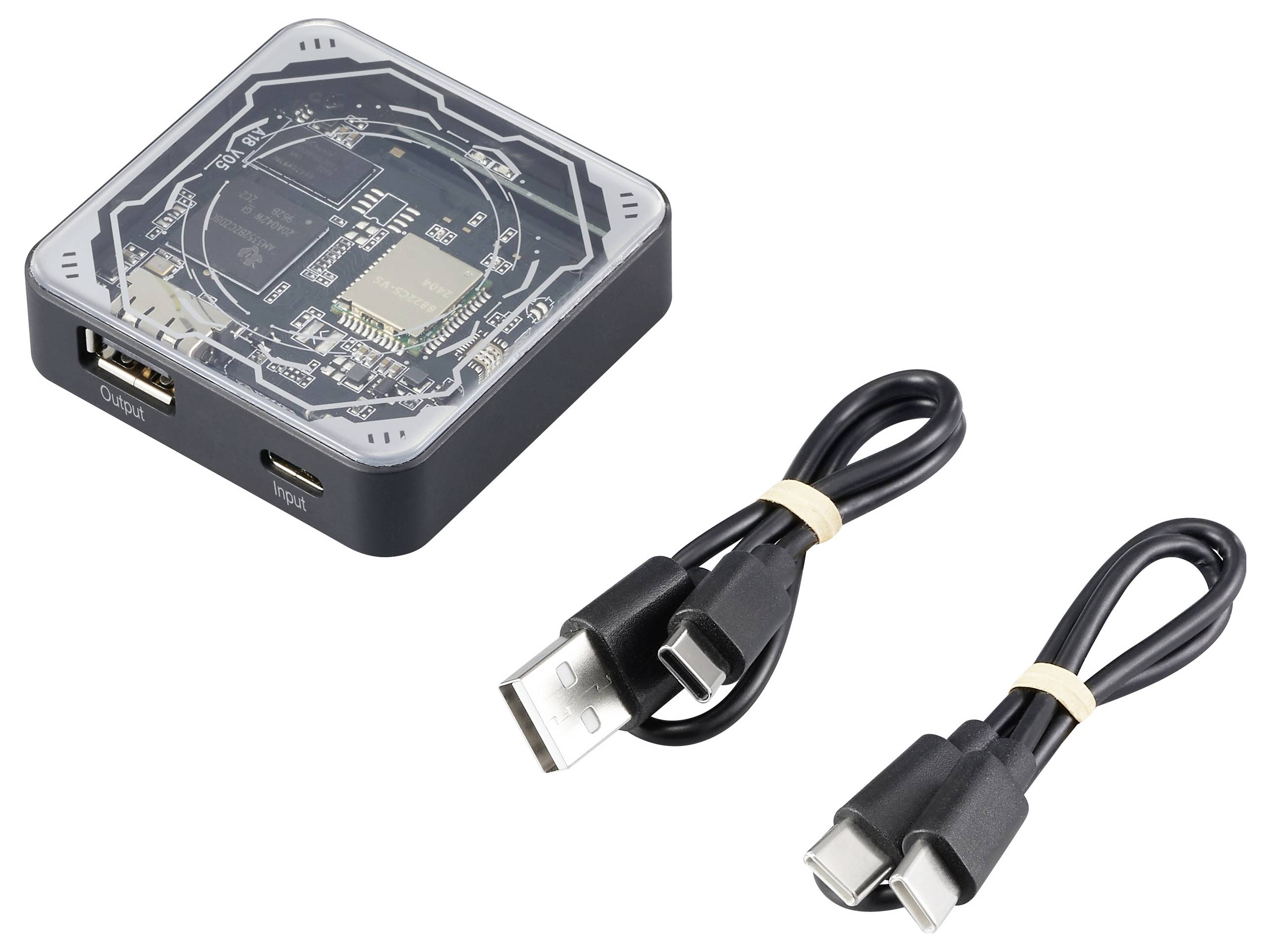 Ein quadratischer, transparenter Adapter mit Anschlüssen und zwei zugehörigen USB-Kabeln. Geeignet zum Anschluss elektronischer Geräte.