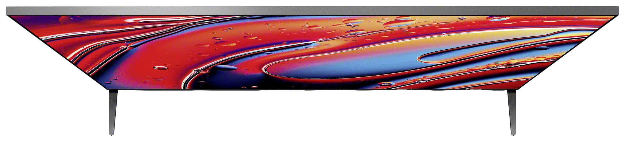 Flacher Fernseher mit lebendigem, buntem Display, zeigt abstrakte rote und blaue Formen. Gerät steht auf zwei schmalen Füßen.