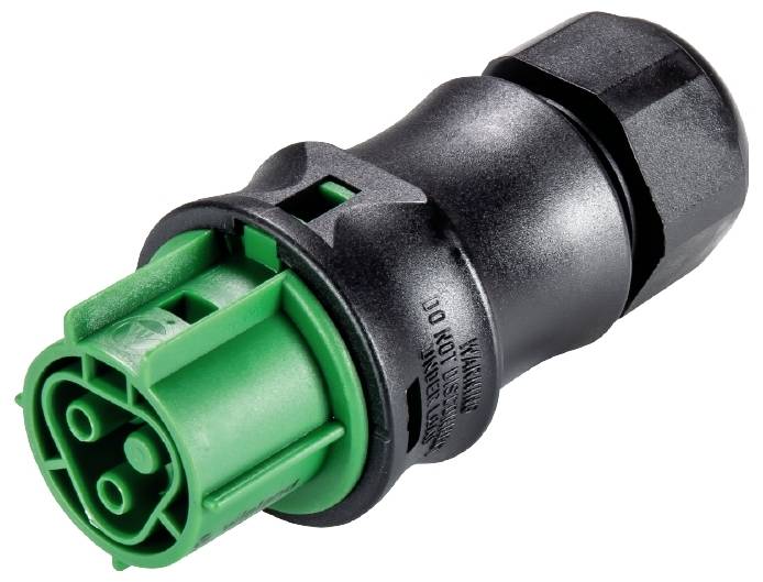 Schwarzer und grüner elektrischer Stecker, mit Warnhinweis. Hauptsächlich für industrielle Anwendungen.