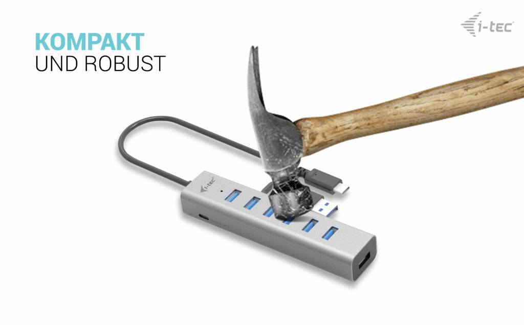 Ein Hammer schlägt auf einen robusten USB-Hub mit mehreren Anschlüssen. Text: 'Kompakt und robust', i-tec-Logo.