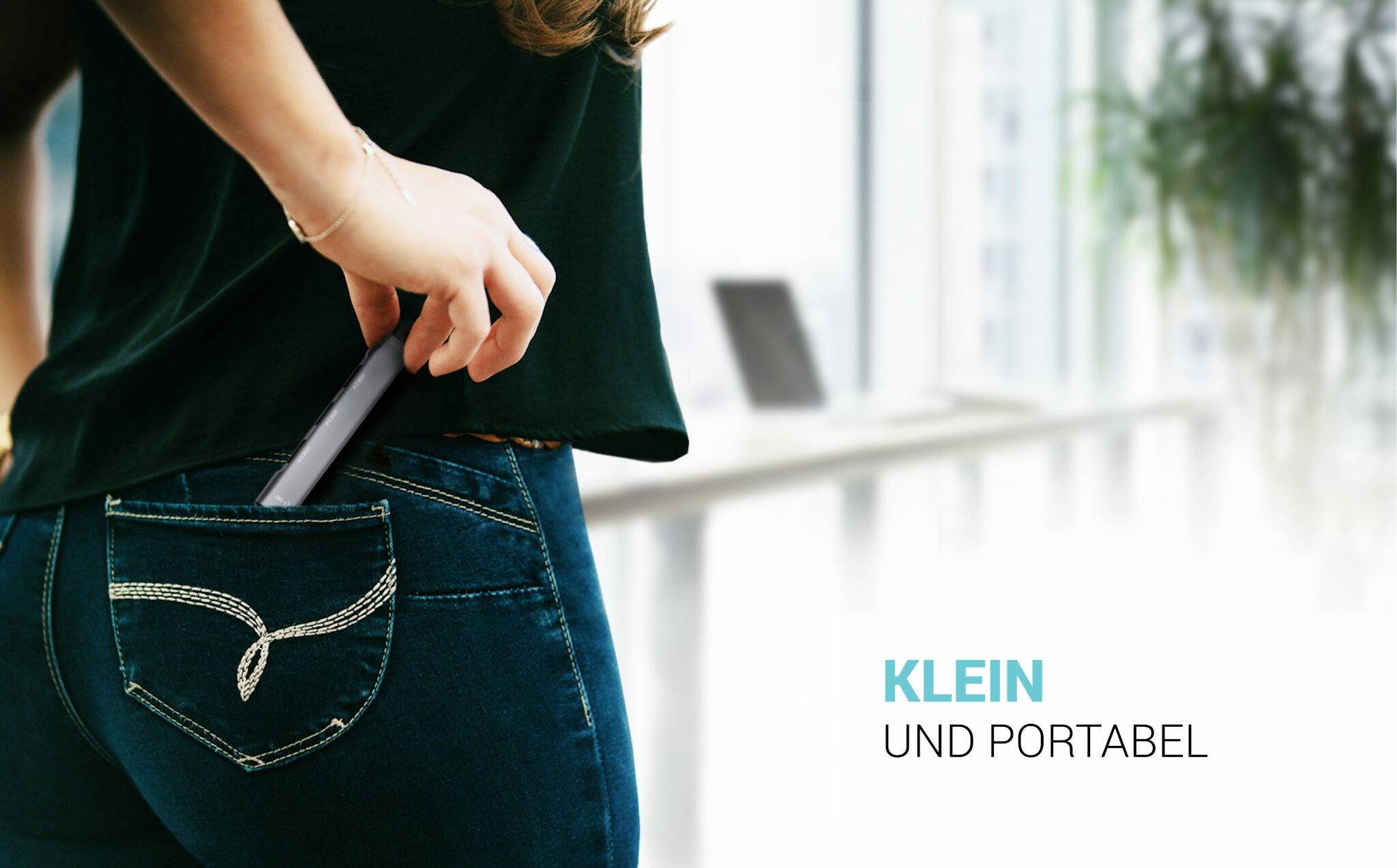 Person steckt ein kleines, tragbares Gerät in die Gesäßtasche einer Jeans. Text daneben: 'Klein und portabel'.