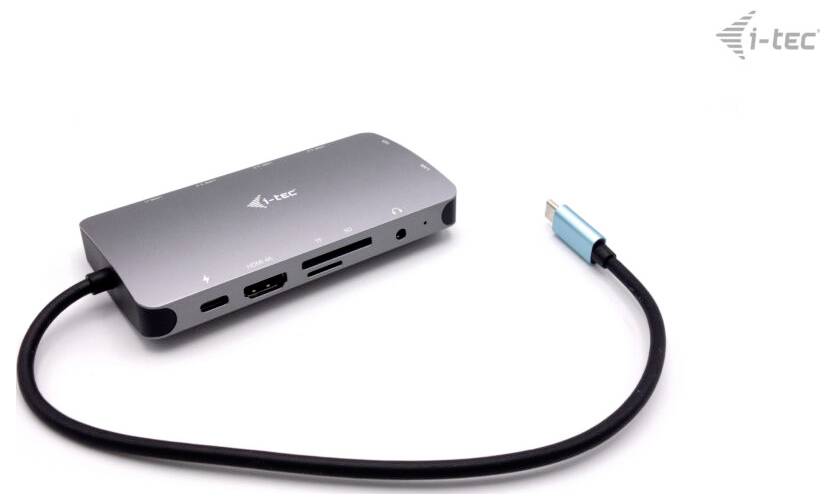 Ein grauer USB-C-Hub von i-tec mit mehreren Anschlüssen, darunter HDMI, USB und Kartenleser. Ein blaues USB-C-Kabel ist angeschlossen.