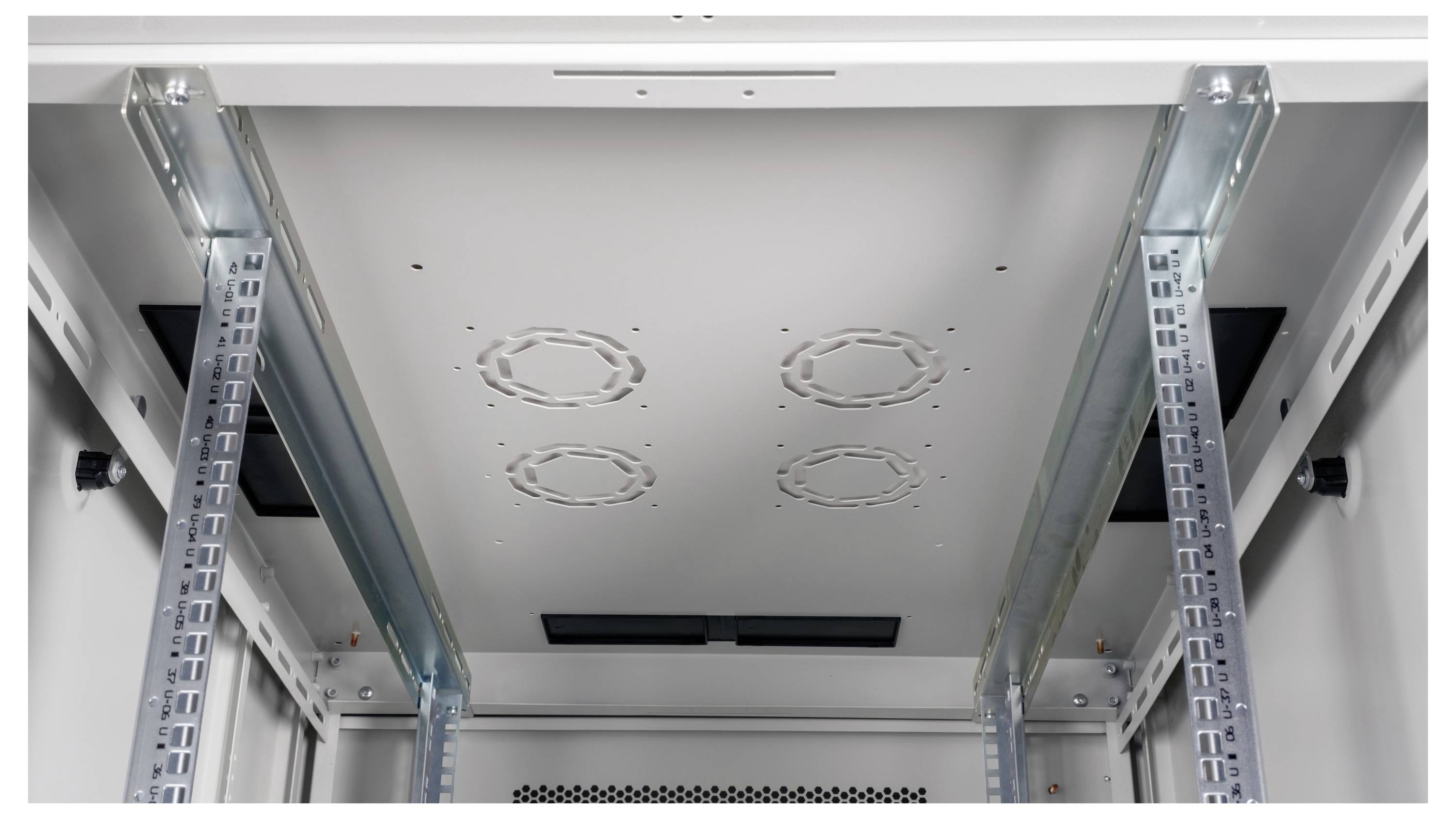 Innenansicht eines leeren Serverracks mit zwei Metallschienen an den Seiten und Belüftungsöffnungen an der Decke.