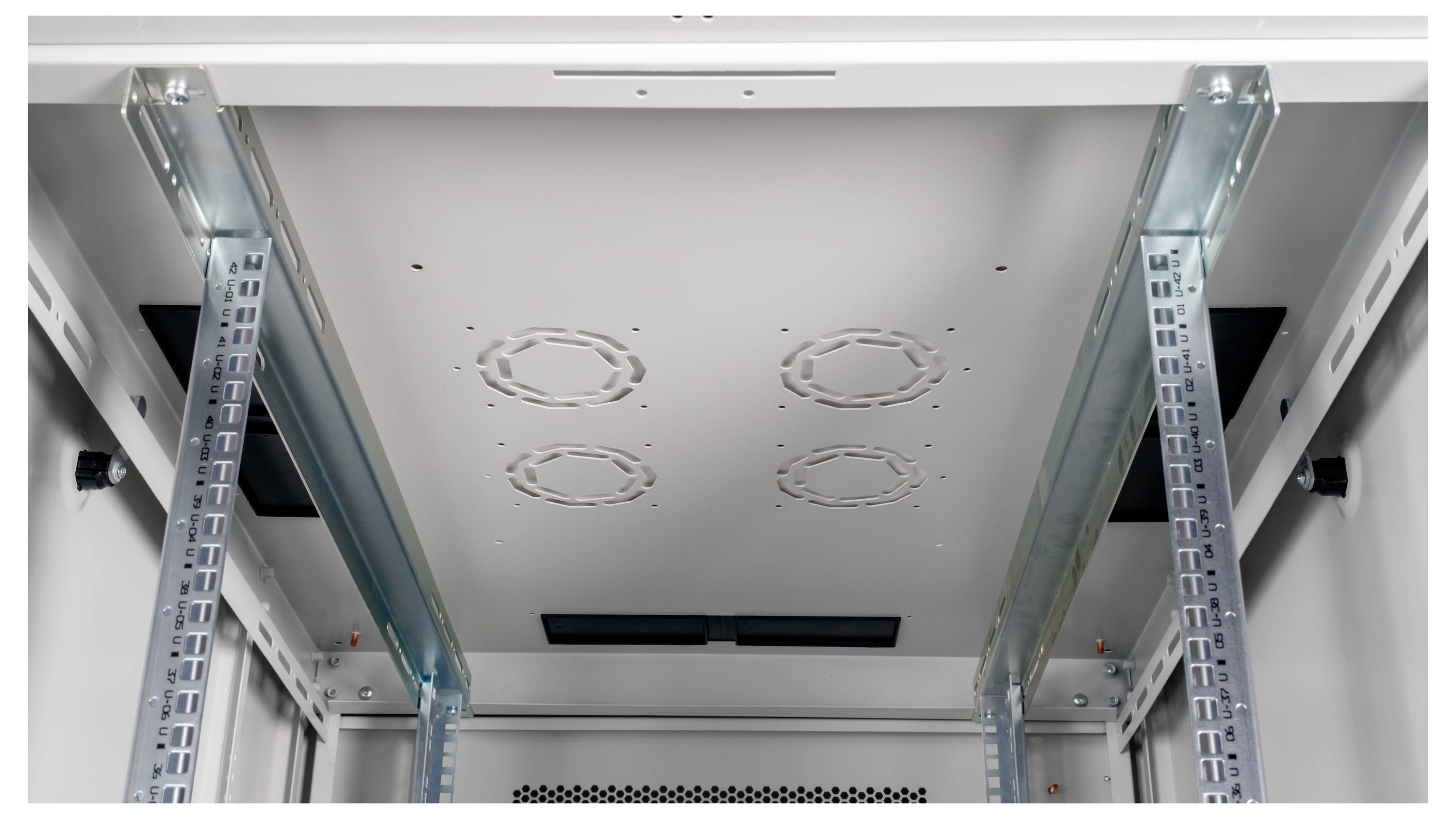 Innenansicht eines leeren Serverracks mit Montageschienen und Lüftungslöchern an der Decke, bereit für Ausrüstungseinbau.