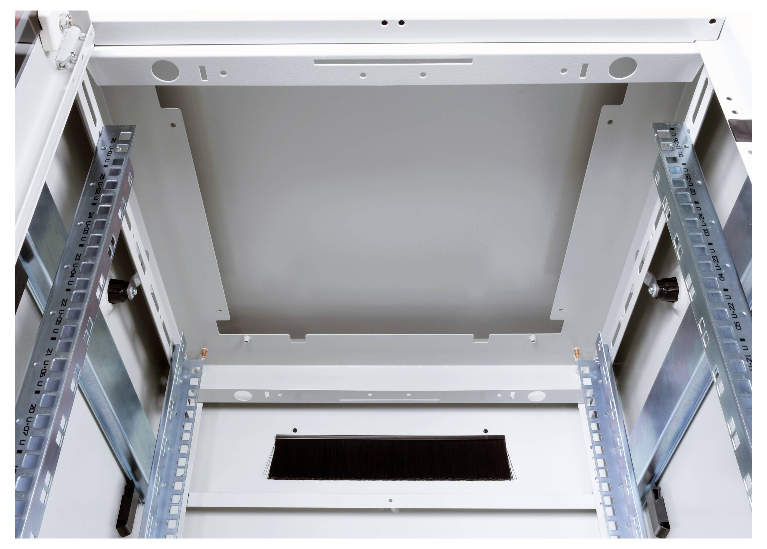 Innenansicht eines leeren Serverracks mit Schienen und Halterungen an den Seiten und einem Belüftungsgitter auf der Rückseite.
