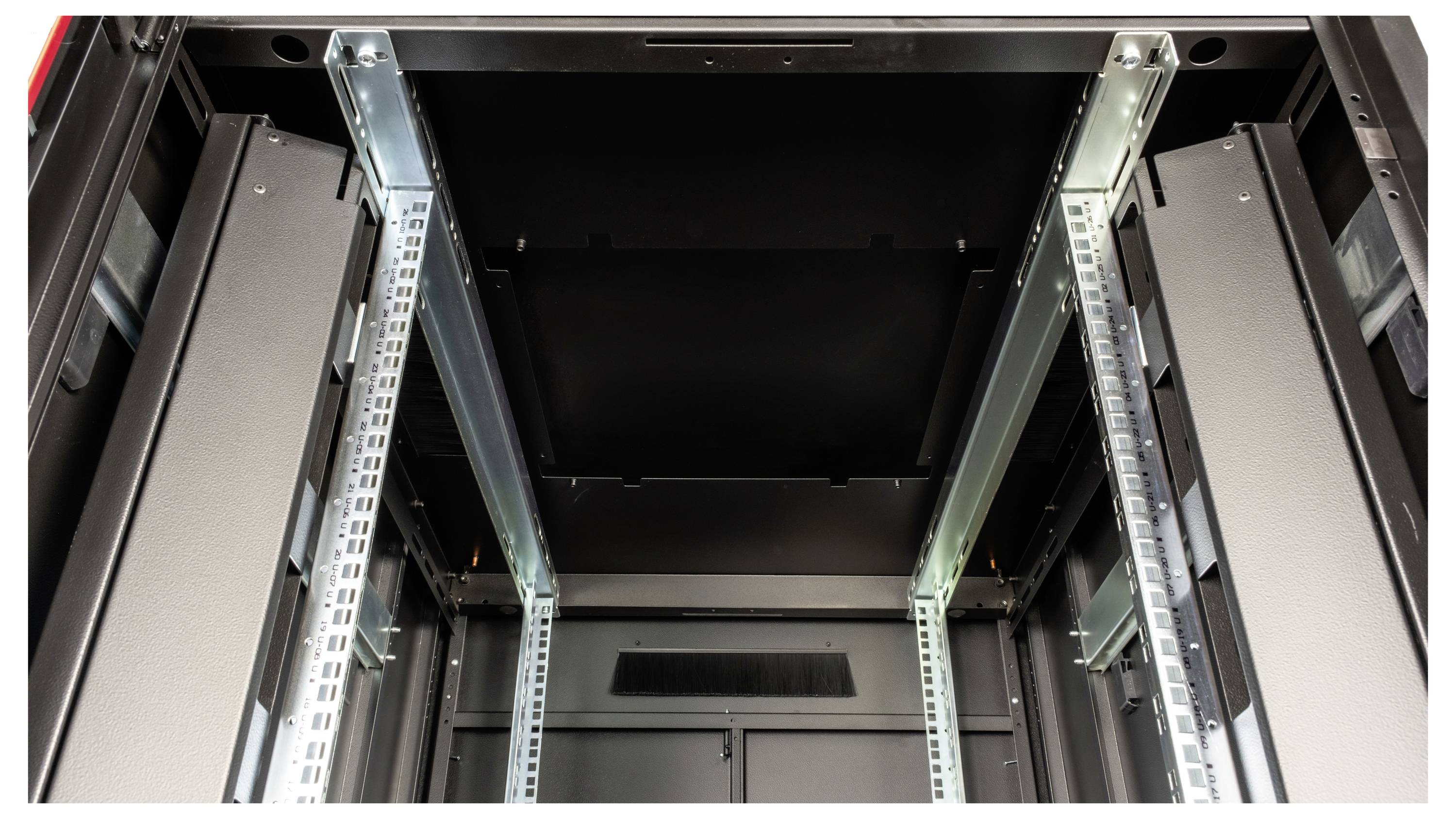 Innenansicht eines leeren Serverracks mit Metallstreben und schwarzen Wänden, bereit für die Installation von IT-Ausrüstung.