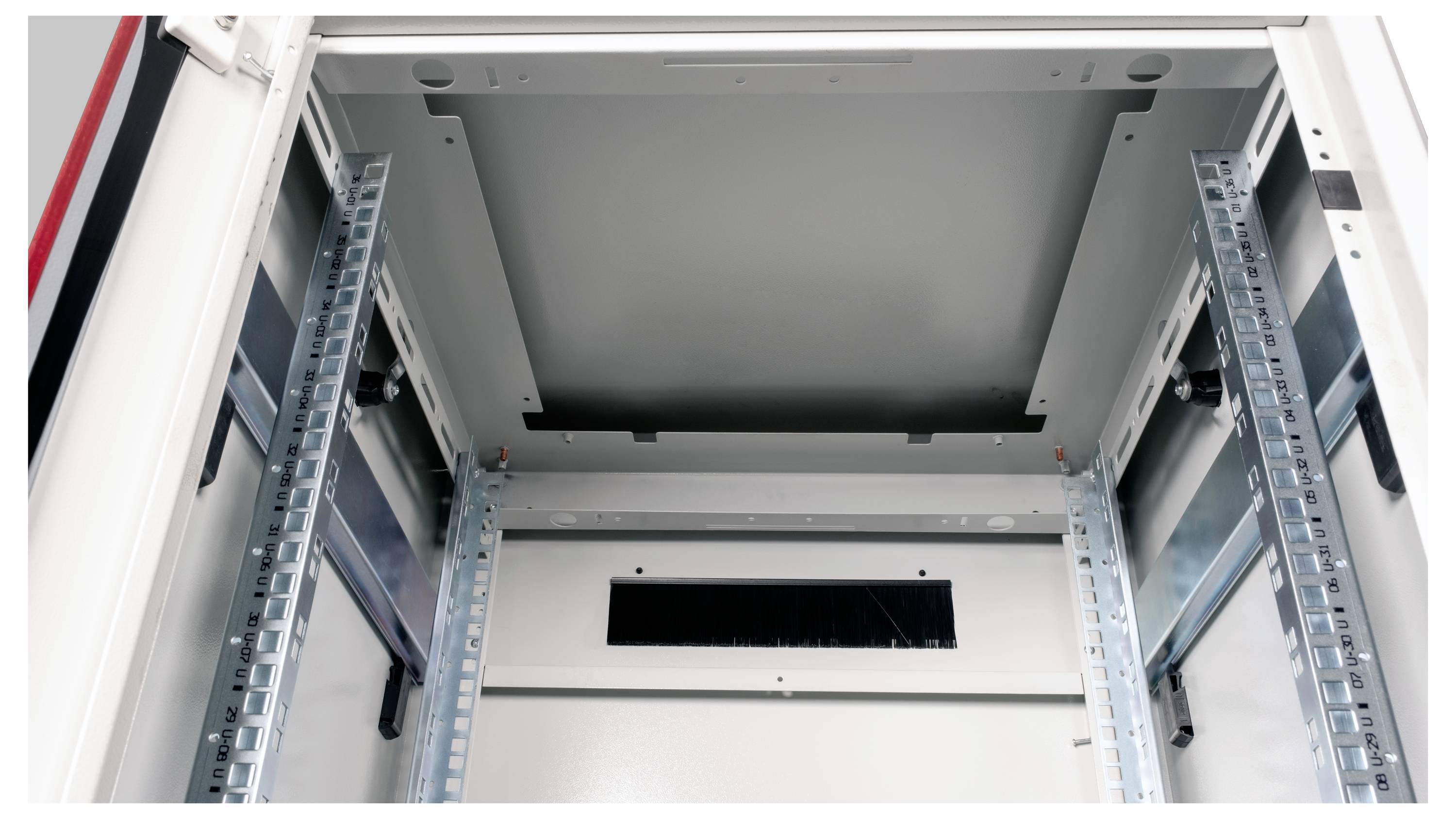 Innenansicht eines leeren Technikschranks mit Metallrahmen und Belüftungsschlitzen, bereit zur Installation von Netzwerkgeräten.