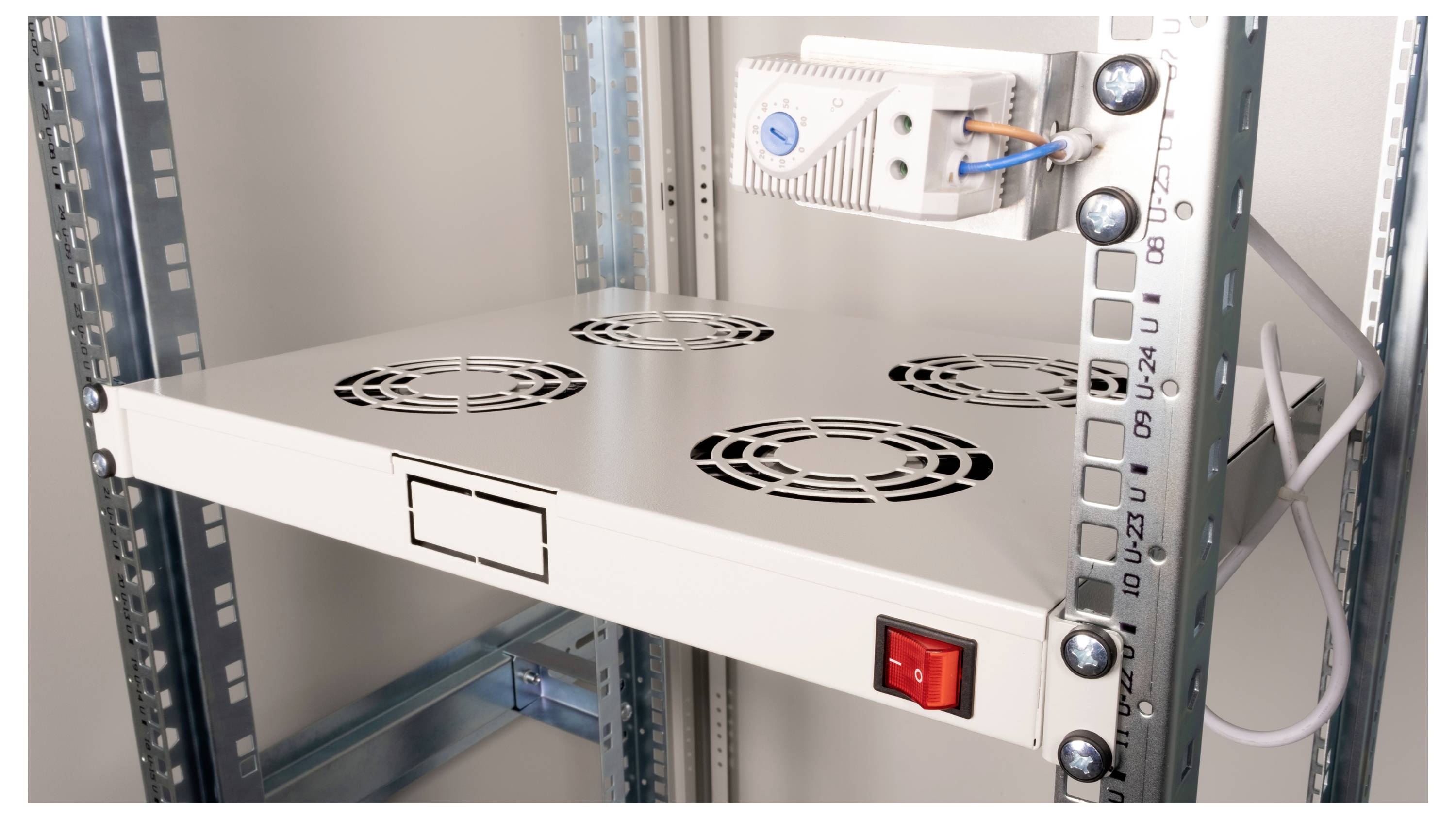 Metallregal mit Lüftern zur Belüftung und rotem Schalter in einem Serverraum.